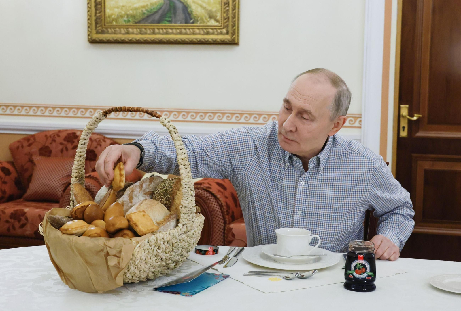 Vladimir Putin, presidente de Rusia, alcanza una pieza de pan este sábado.
