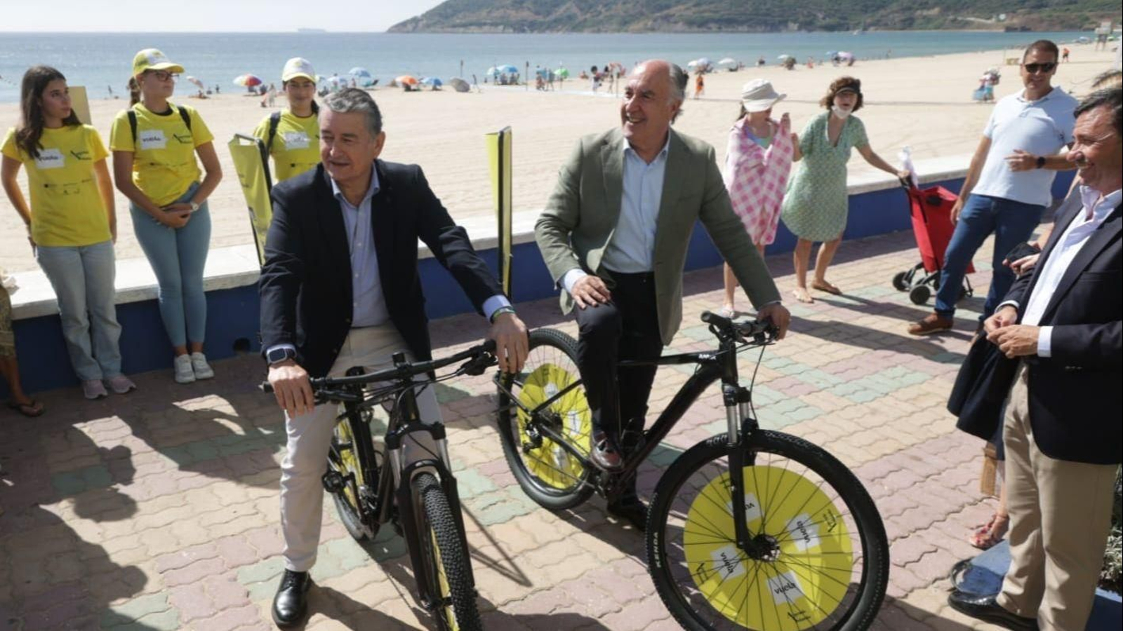 El consejero de la Presidencia, Antonio Sanz, acompañado por el alcalde de Algeciras, José Ignacio Landaluce, montan en bicicleta en la playa de Getares.