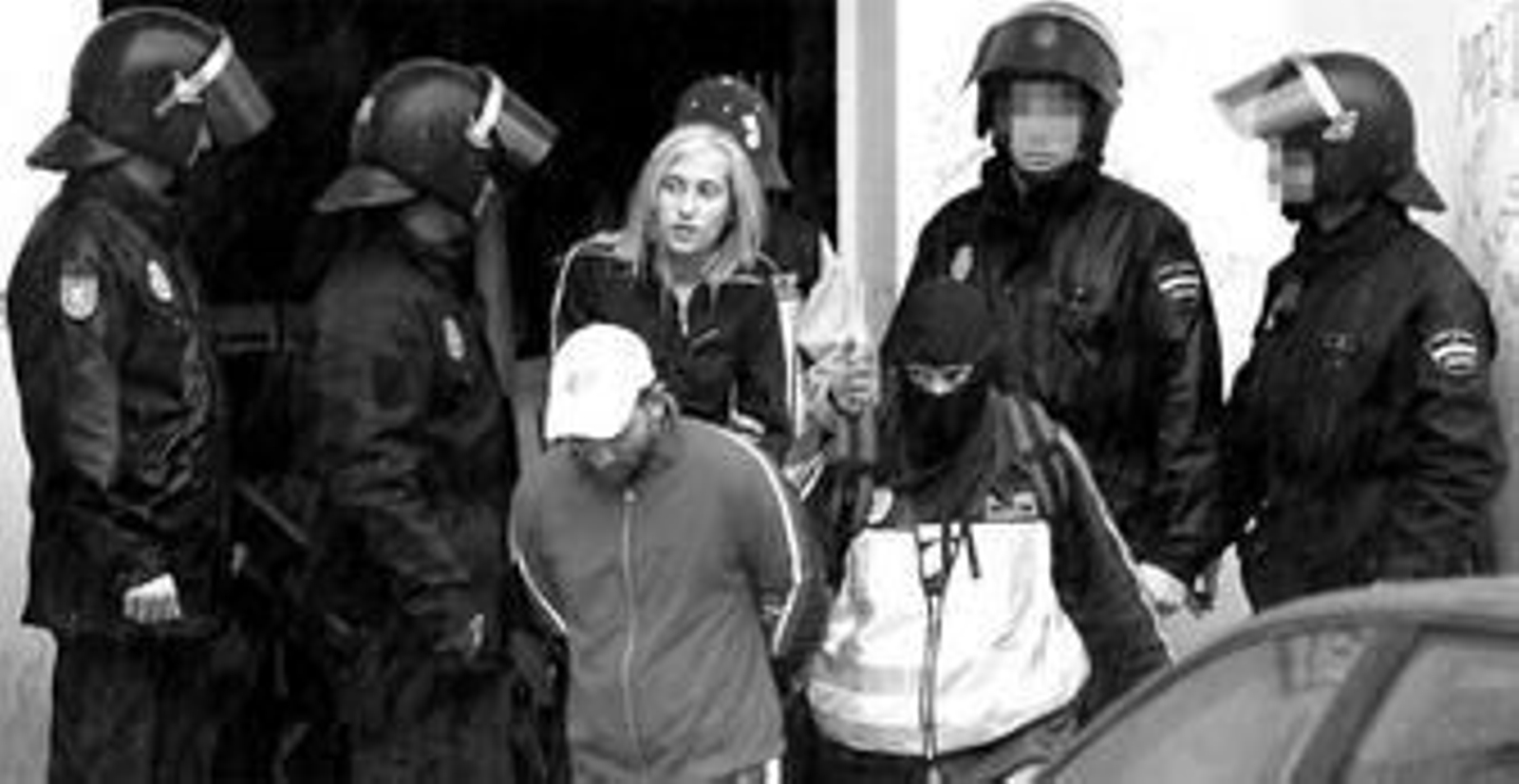 1. Instante en el que los agentes de la Policía Nacional trasladan a dos de los detenidos en la operación realizada ayer en el barrio de Las Albarizas de Marbella contra un clan de supuestos traficantes 2. Dos policías transportan el ariete que tuvieron que emplear para derribar las puertas de los domicilios en los que se encontraban los sospechosos. 3. Pequeño invernadero desmontable en el que presuntamente se cultivaba marihuana.