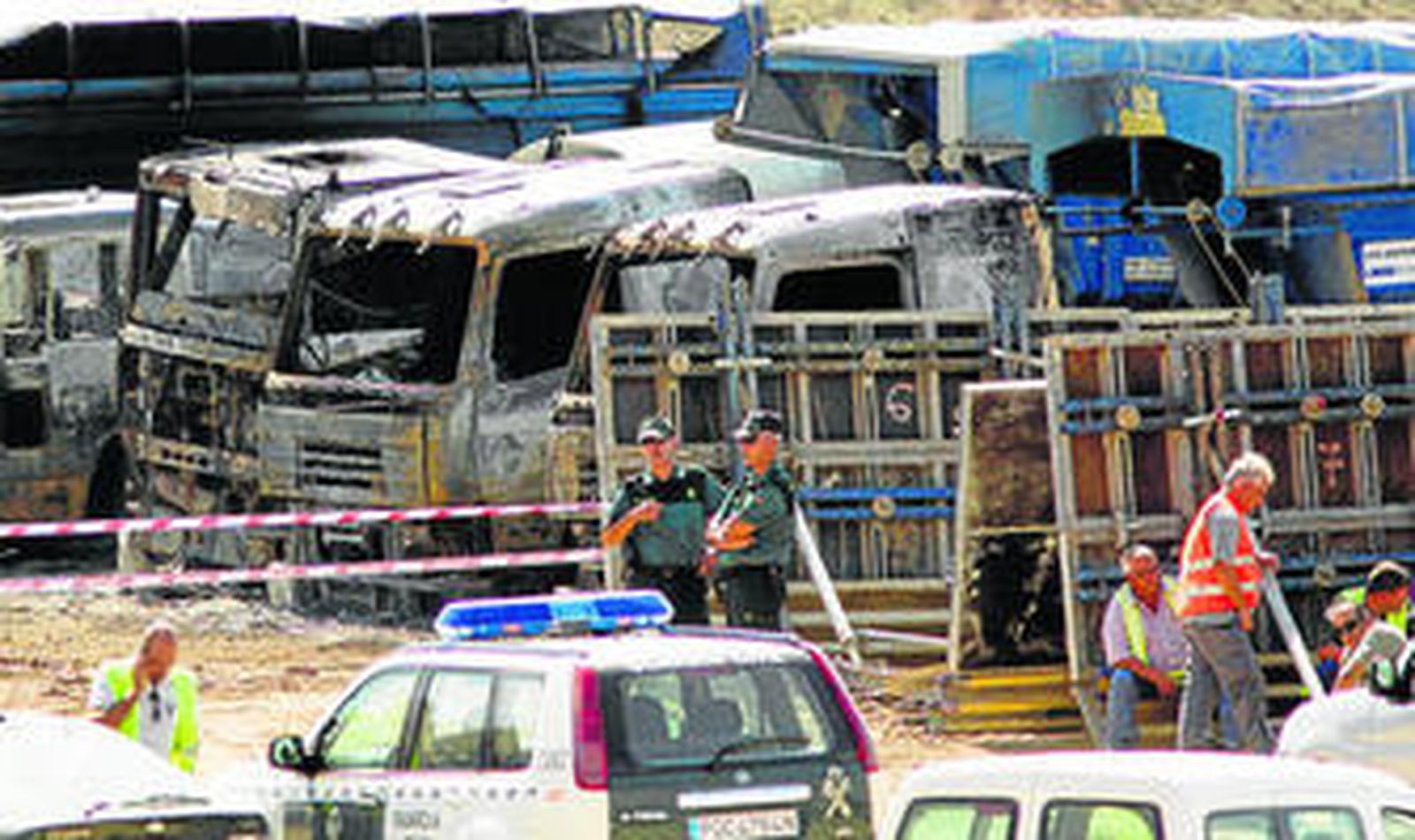 Dos guardias civiles delante de la fila de camiones que ardieron tras el sabotaje.