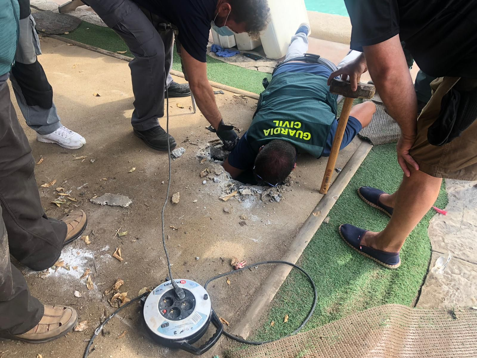 Un guardia civil introduce su brazo en un zulo en el marco de la Operación Dismantle.