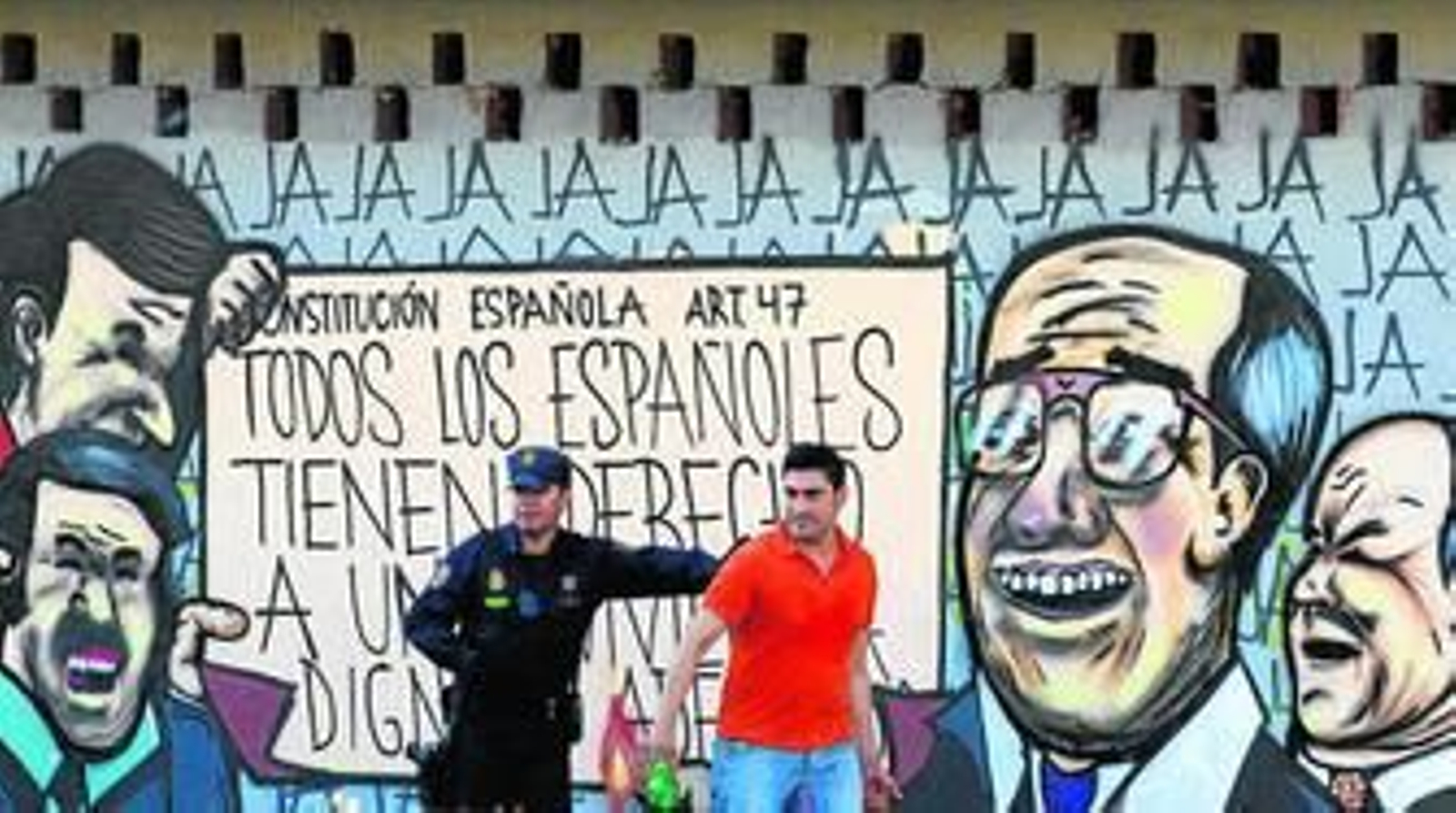 Un agente de la Policía Nacional y uno de los ocupantes del edificio, durante el desalojo del pasado domingo.