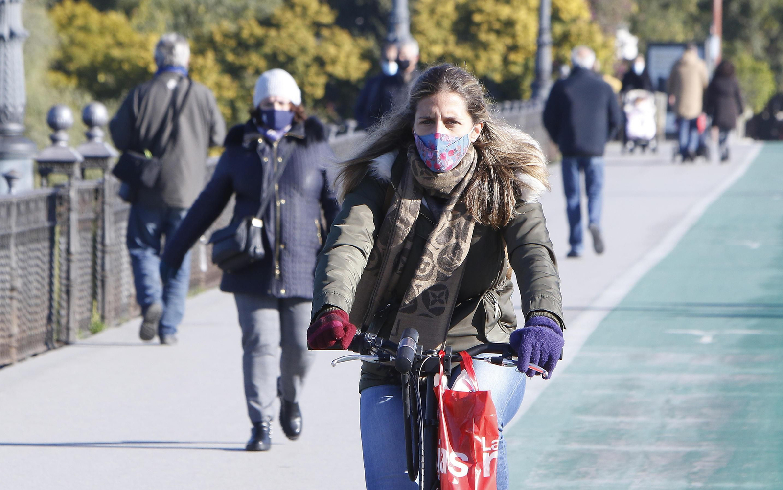 Una mujer en bici y protegida del frío. Una mujer en bici y protegida del frío.