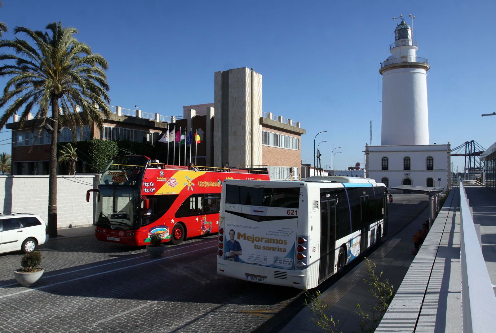 Un autobús de Sightseeing pasa frente a uno de la EMT.