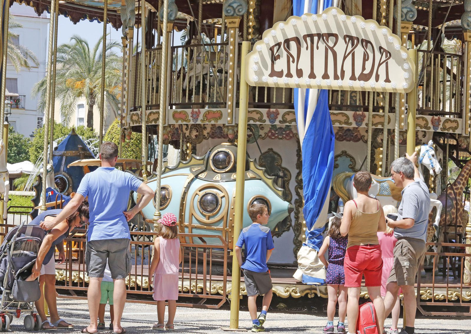 Retrospectiva de turistas ante el carrusel de la plaza del Arenal.