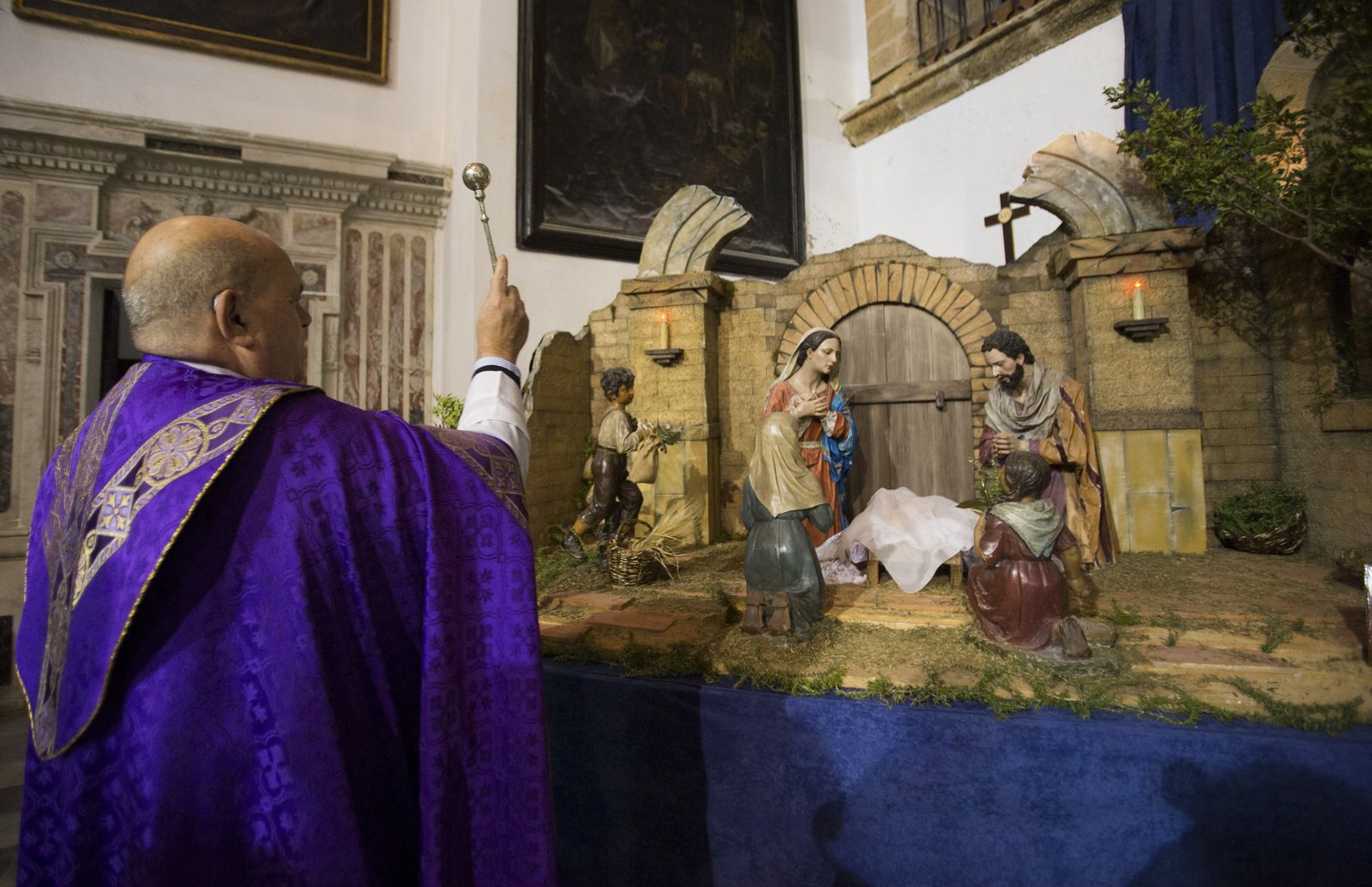 Rafael Fernández Aguilar, párroco de Santa Cruz, bendice el Belén cuyo portal ha sido realizado por presos.