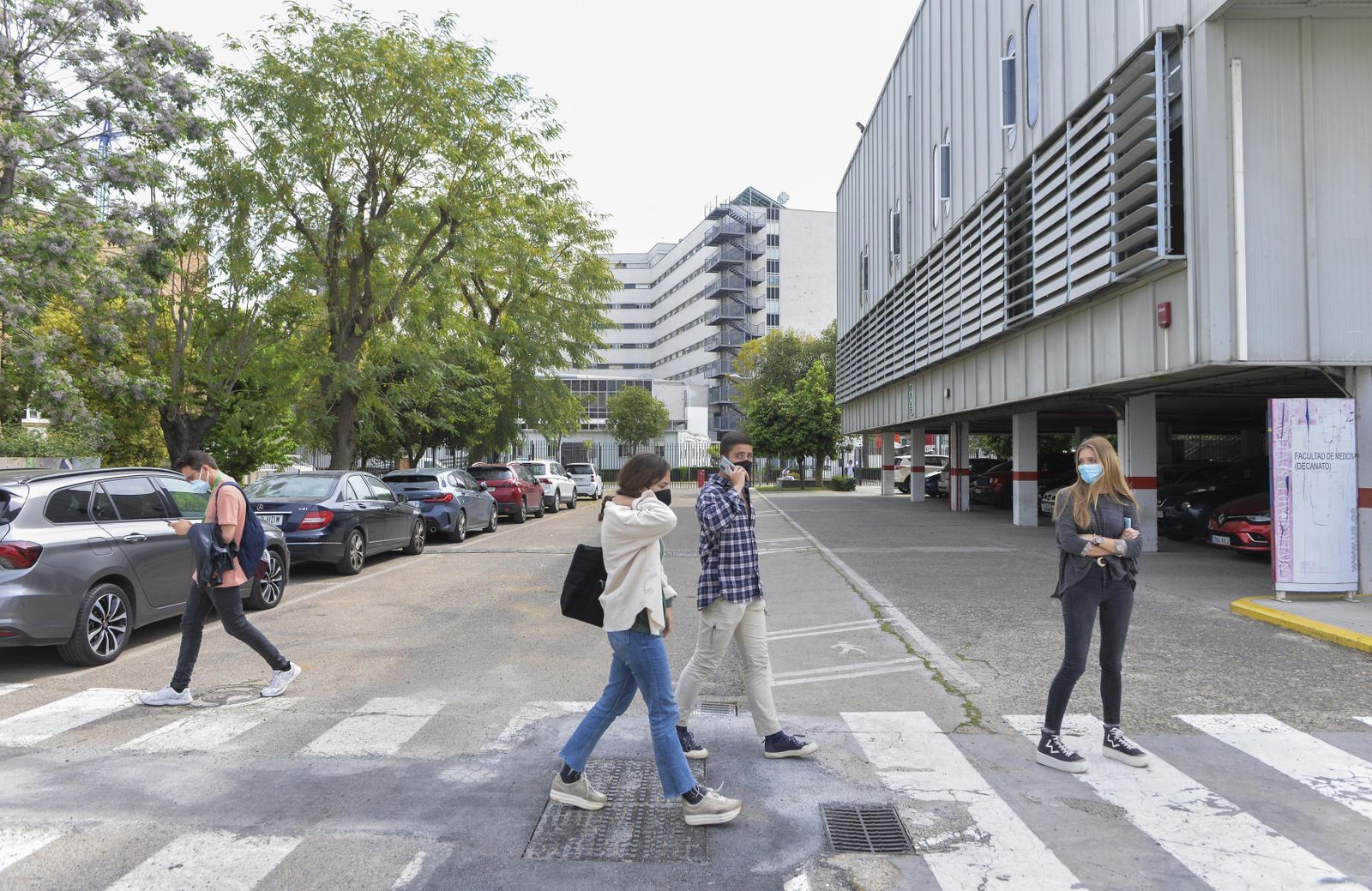 Varios jóvenes cruzan por un deteriorado paso de peatones en el interior del Campus de Medicina.