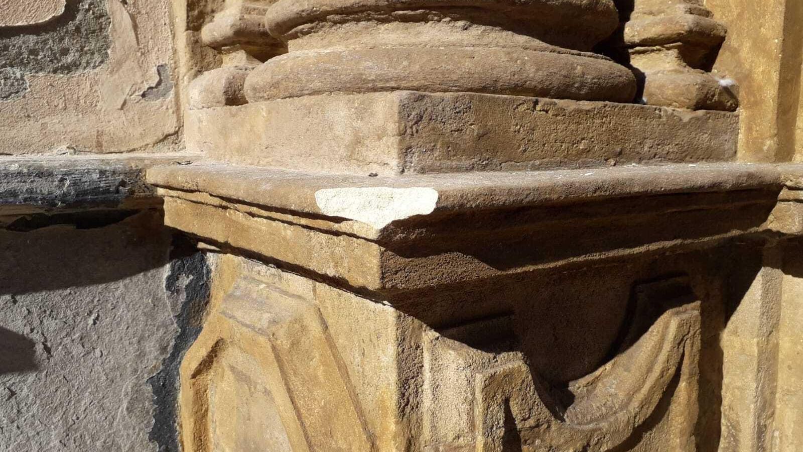 Detalle del trozo de piedra arrancado en la portada de la iglesia de San Antonio.