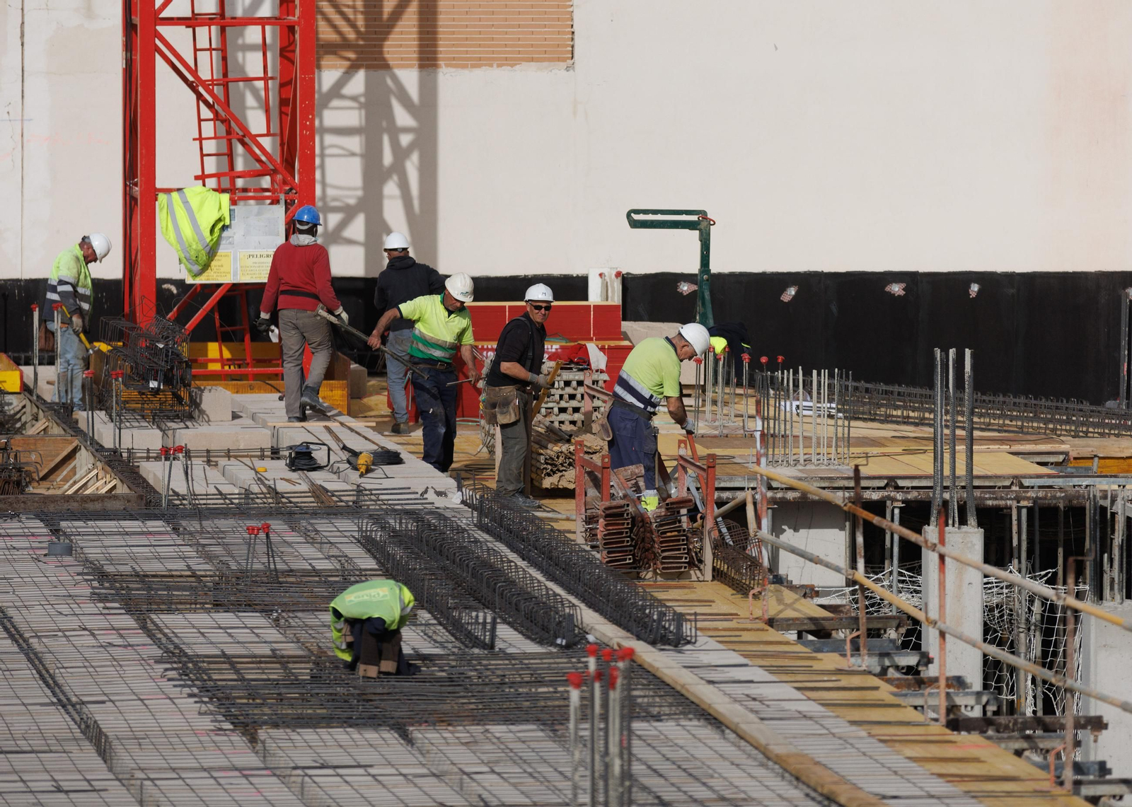 Varios trabajadores llevan a cabo la construcción de un edificio de viviendas.