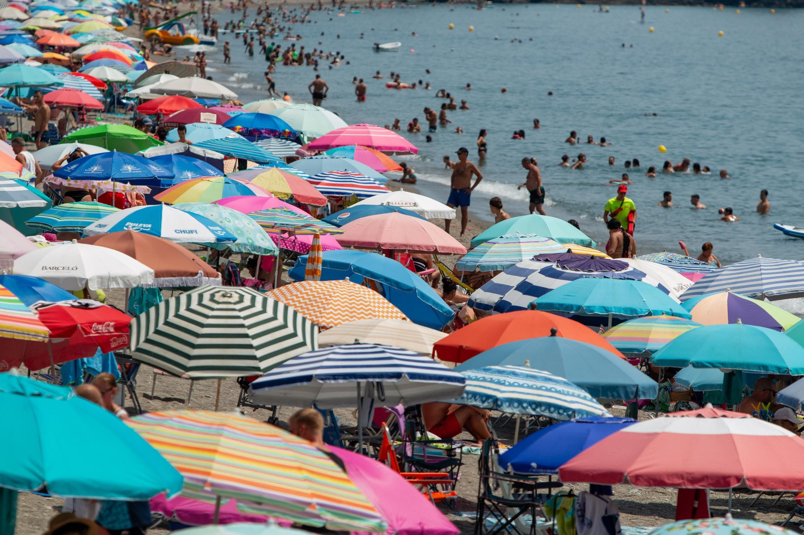 Multitud de personas se refugian de las altas temperaturas en la playa de San Cristóbal, en Almuñécar