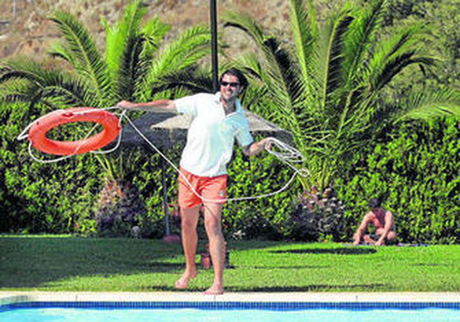 Un socorrista lanza un salvavidas en una piscina de la capital.