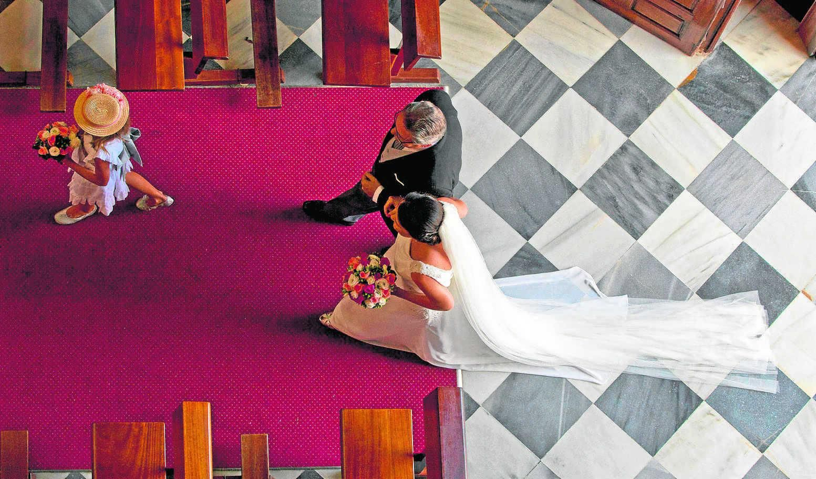 Una mujer entra vestida de novia en una iglesia antes de contraer matrimonio.