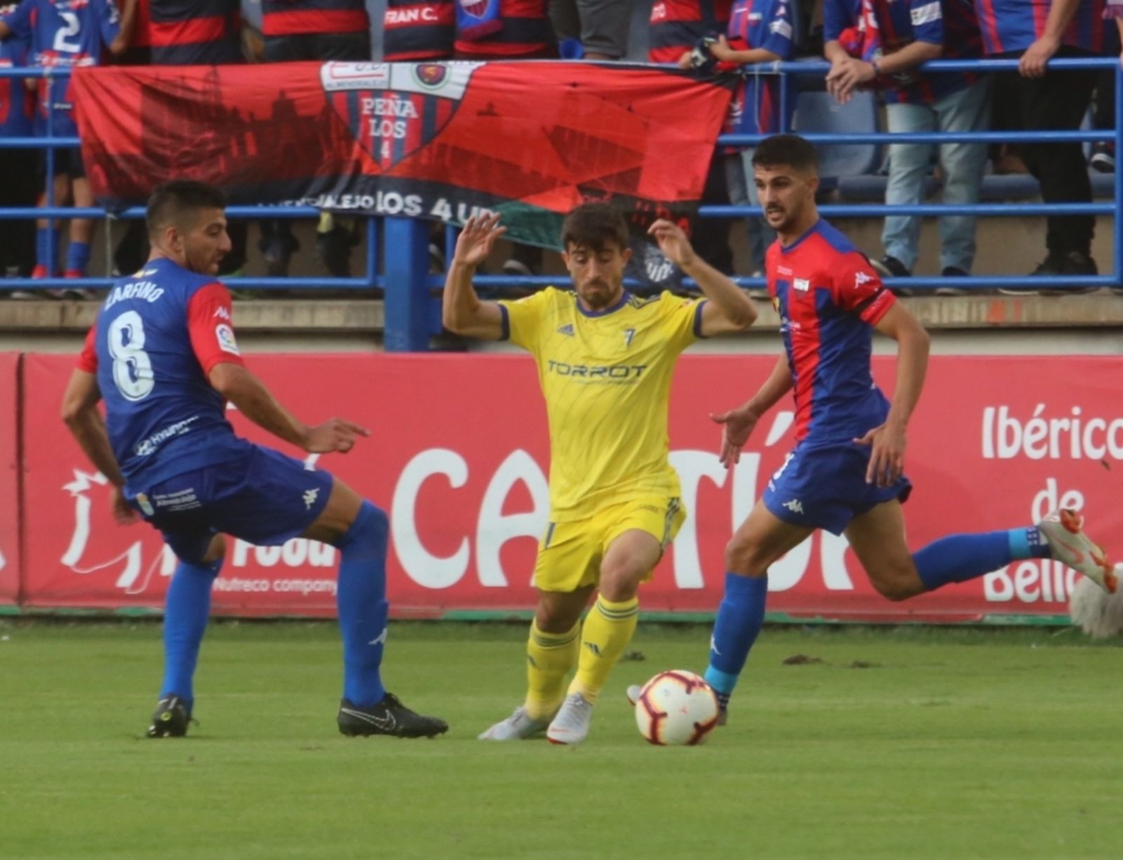 Jairo, con el balón entre dos jugadores del Extremadura.