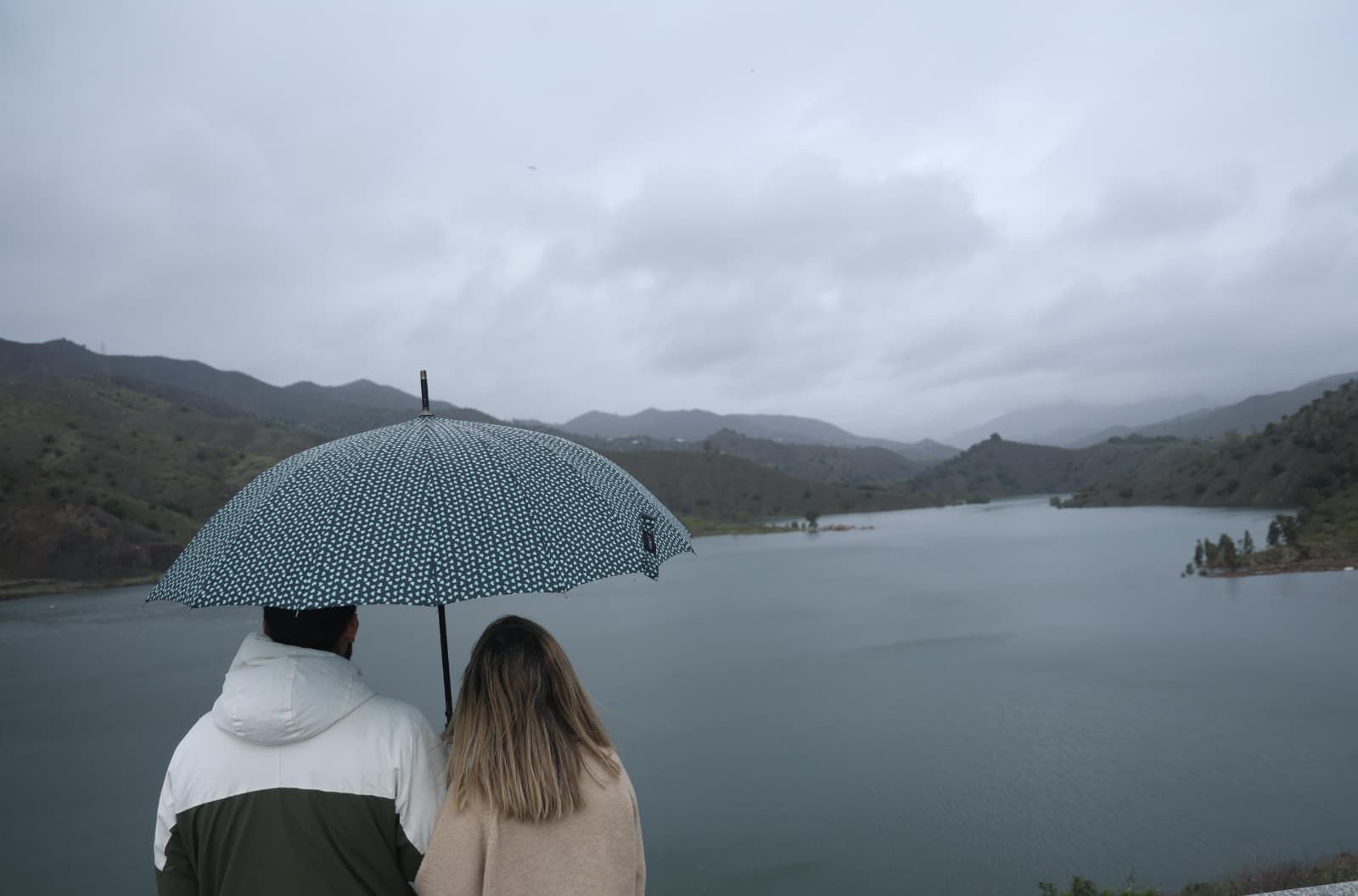 Dos personas contemplan los efectos de la borrasca en un pantano.