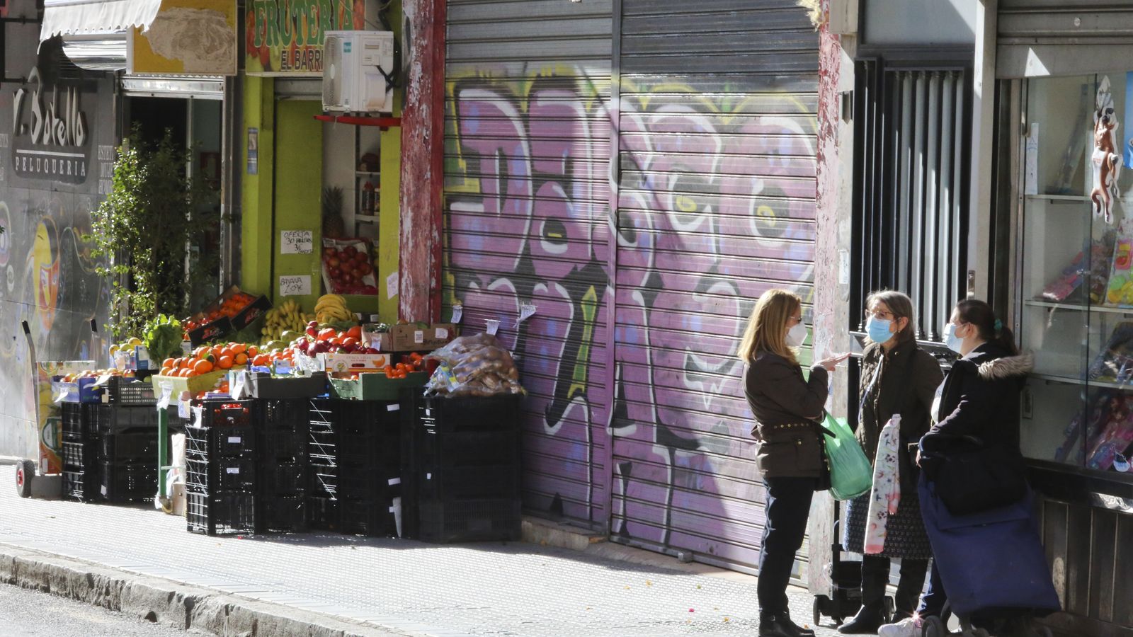 Asamblea de vecinas en la acera con la mercancía de la frutería a tiro.