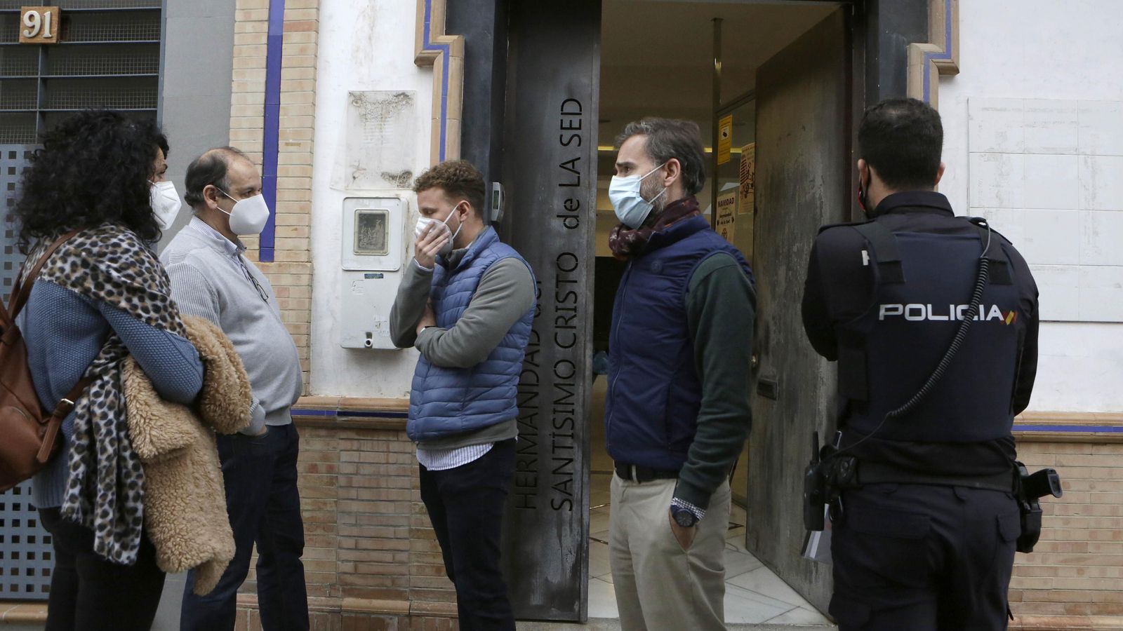 Policías y hermanos de la Sed, en la puerta de la casa hermandad.