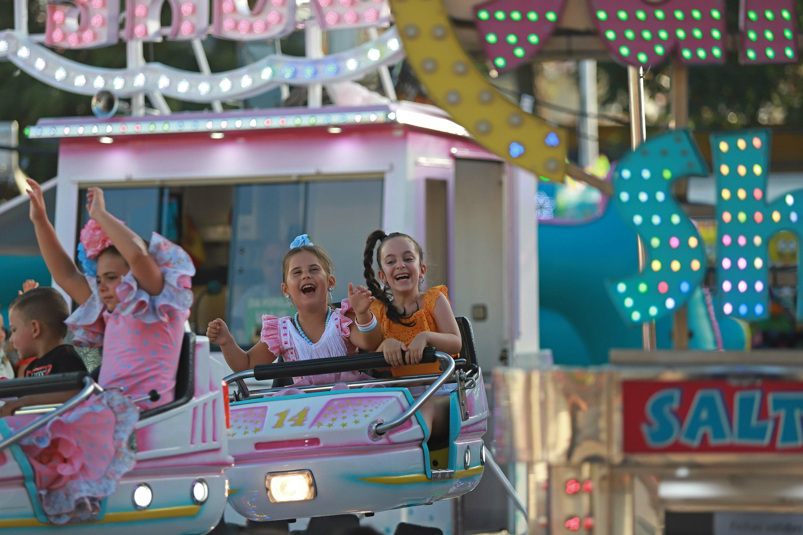 Varios niños disfrutan de una atracción de feria en Algeciras