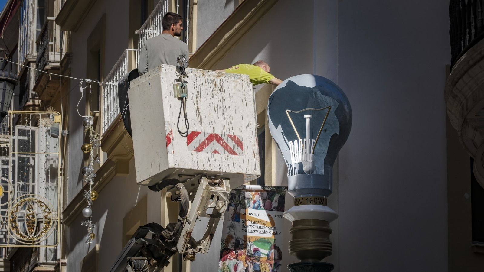 Unos especialistas, reinstalando la gran bombilla en su lugar original.