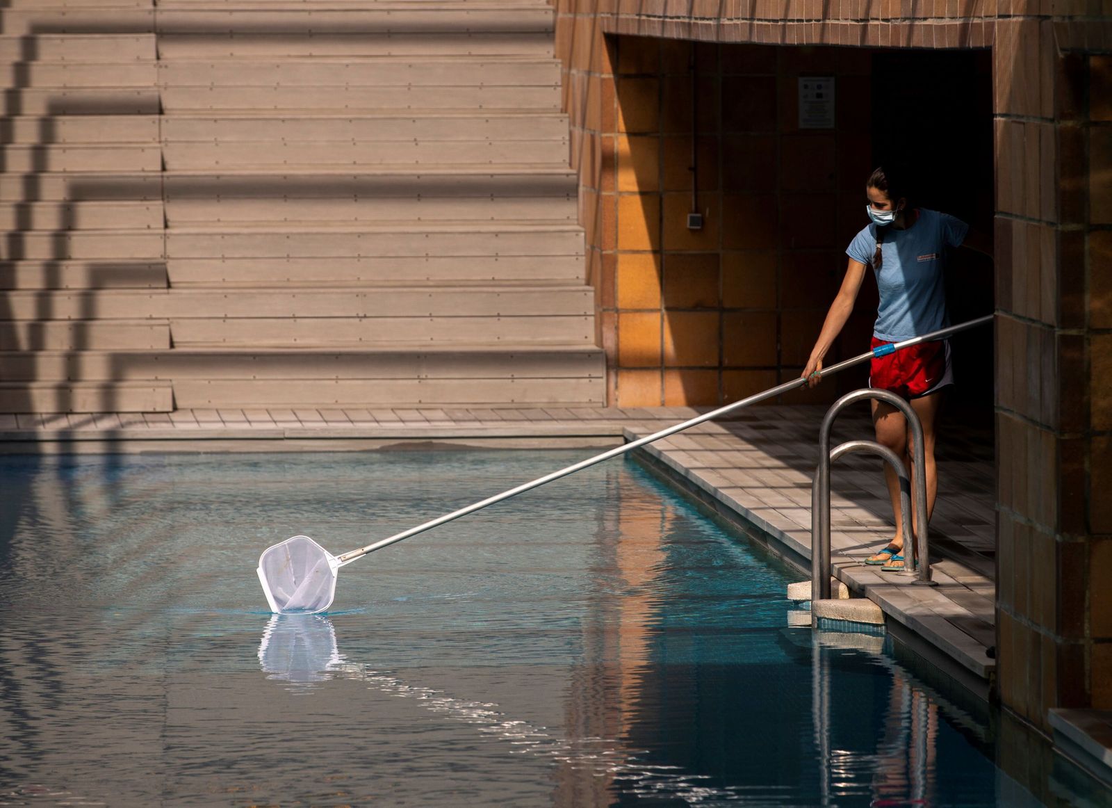 Una socorrista prepara una piscina para su apertura
