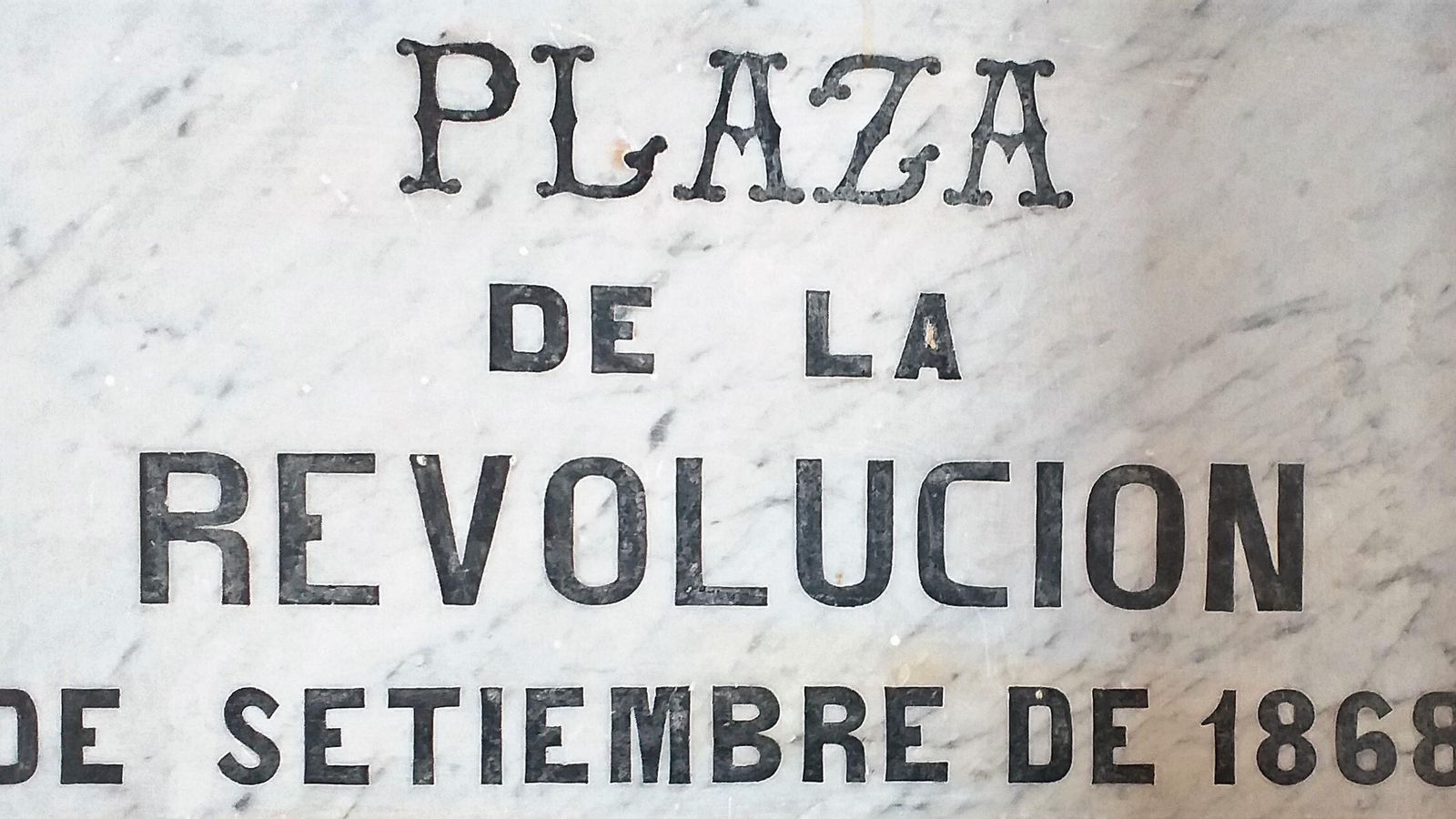Placa de mármol nombrando la “Plaza de la Revolución de Setiembre de 1868”, vigente durante el Sexenio Revolucionario (1868-1874).