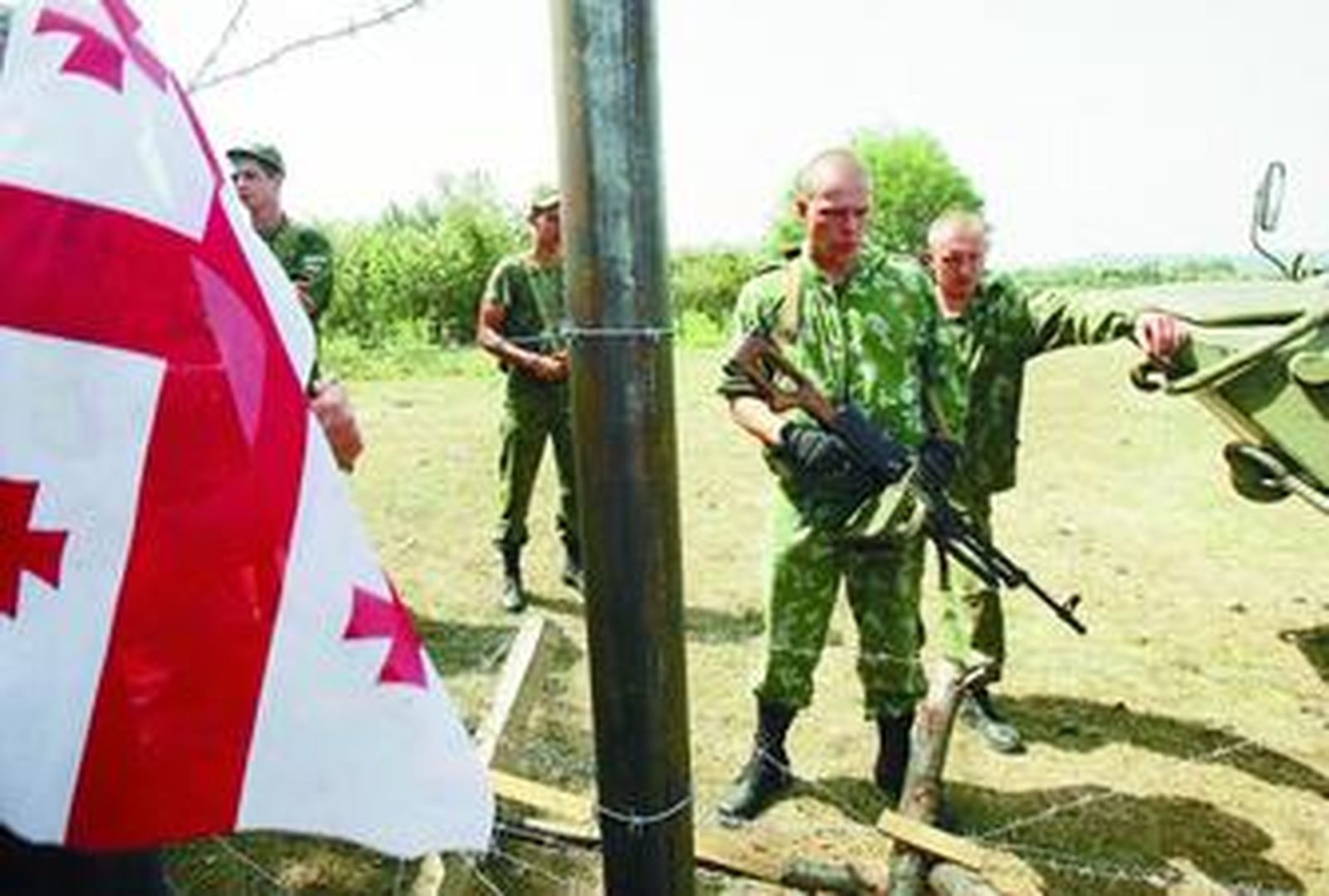 Manifestantes georgianos cuelgan una bandera de su país frente a un puesto de las tropas rusas en Georgia.