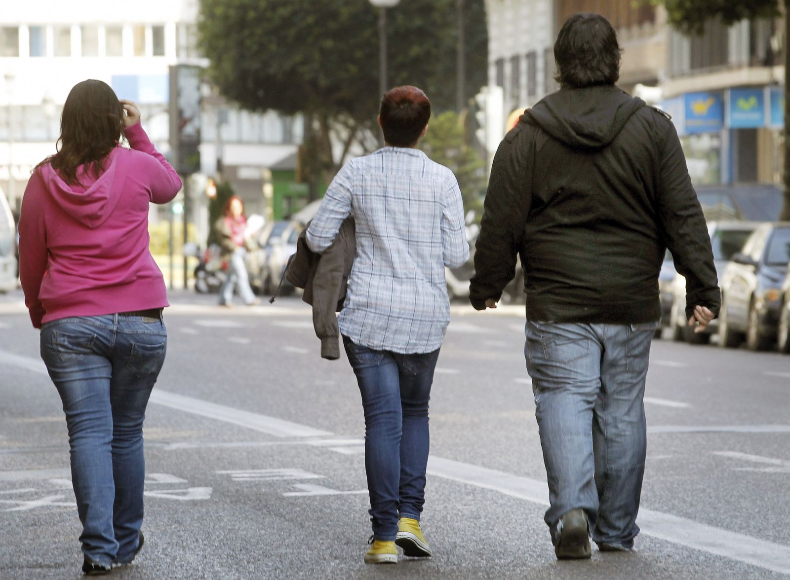 Tres jóvenes pasean por una calle de la capital valenciana.