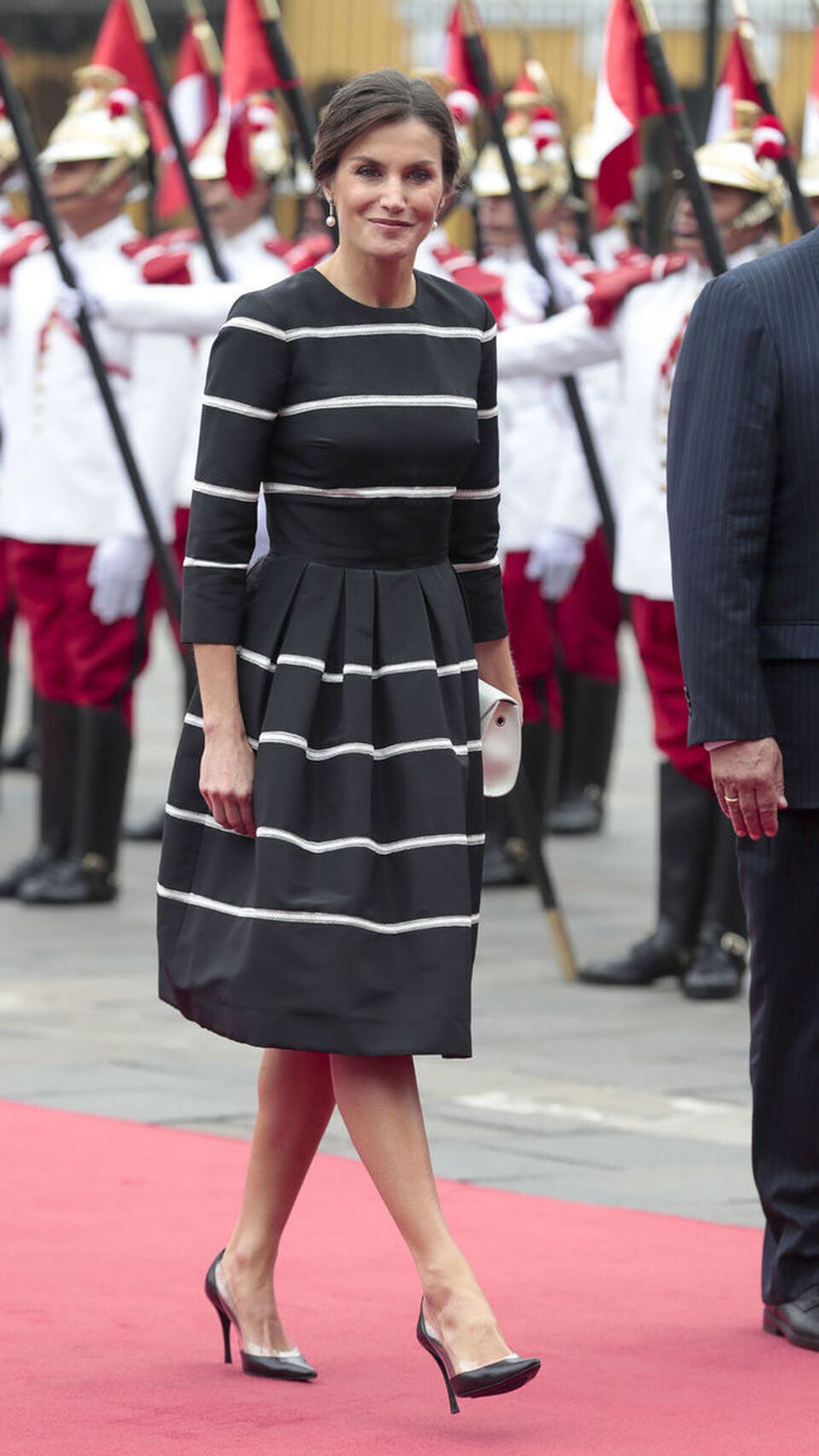 Doña Letizia, con el vestido azul marino de rayas blancas de Carolina Herrera.
