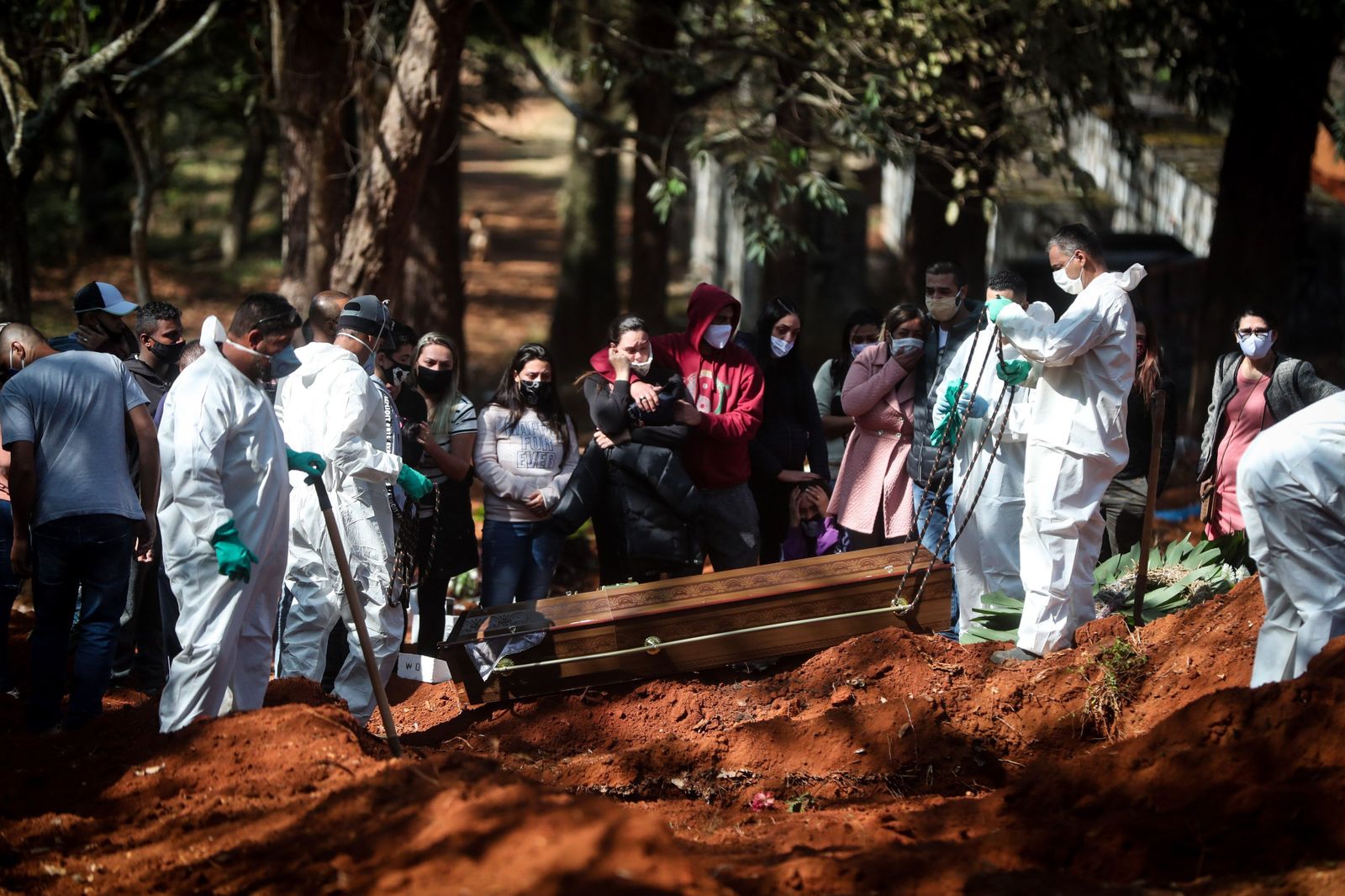Sepultureros entierran un féretro en una fosa en Sao Paulo