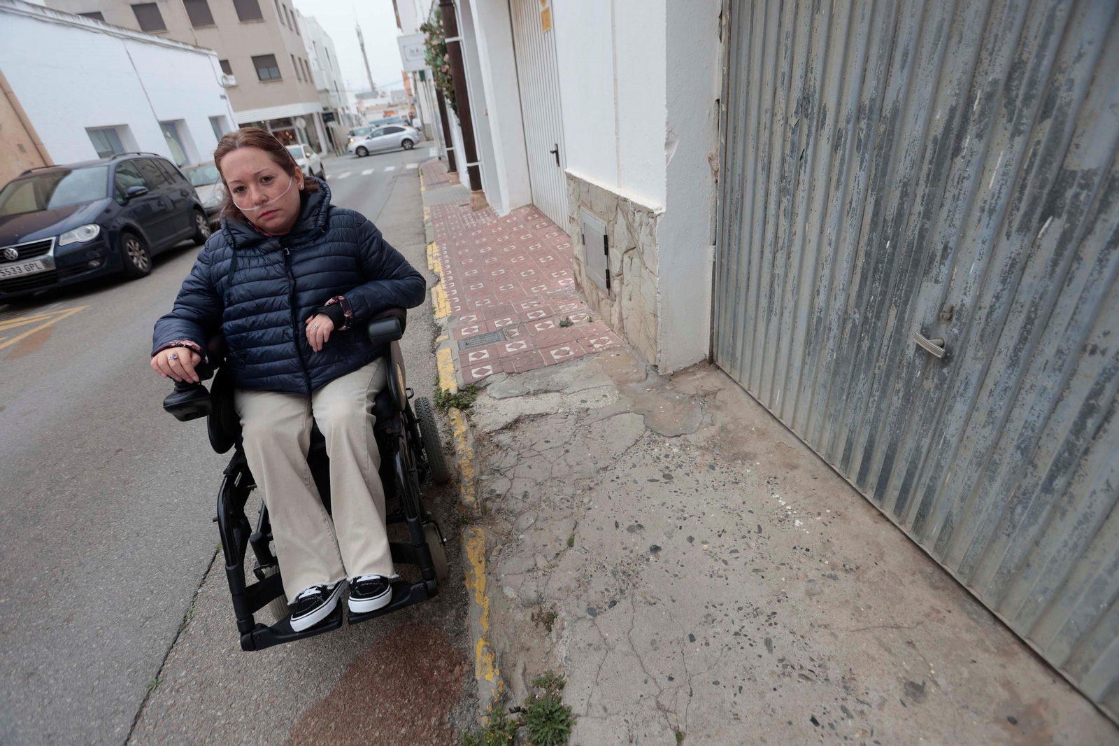 María del Amor León Meléndez transita por la carretera en la calle Pío XII por los múltiples obstáculos en la acera.