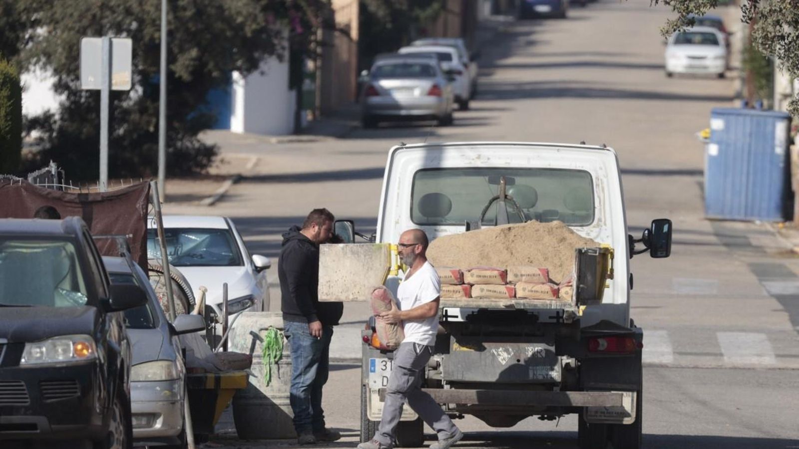 Albañiles descgaran material en una urbanización de chalés, las que suelen buscar los militares de EEUU para vivir en los pueblos del entorno.