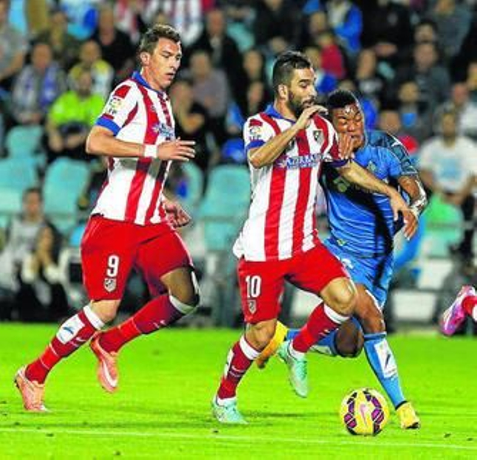 Arda Turan conduce un balón a pesar de la oposición del colombiano Hinestroza.