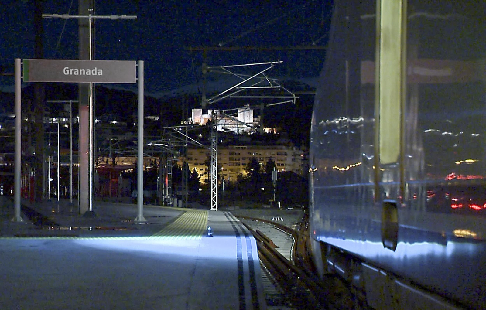 Tren con cartel y la Alhambra al fondo