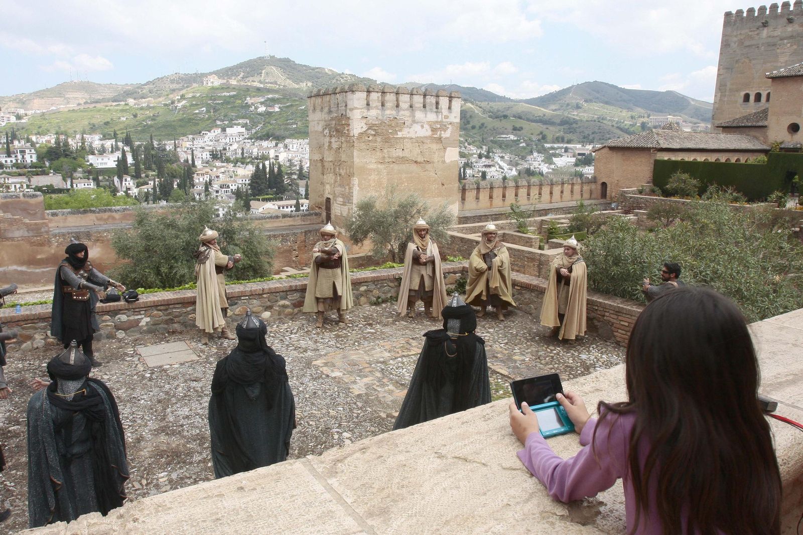 Una niña observa a un grupo de extras en uno de los rodajes desarrollados en la Alhambra.