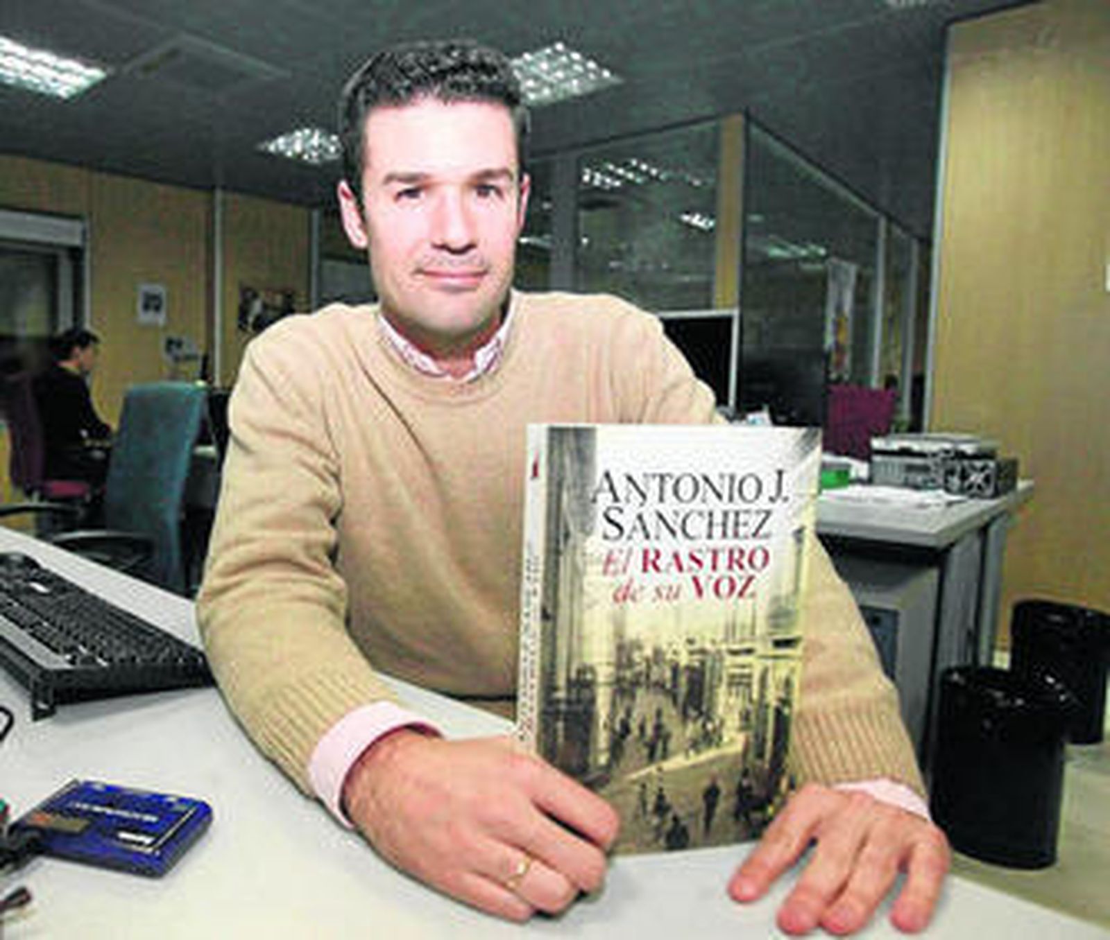 Antonio J. Sánchez, mostrando un ejemplar de la novela, en la redacción de 'Huelva Información'.