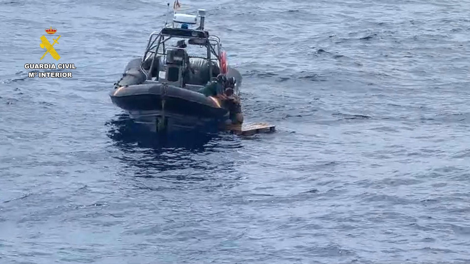 Agentes de la Guardia Civil ayudan al hombre que quedó a la deriva sobre un palé con el que quería ir de Tenerife a Gran Canaria.