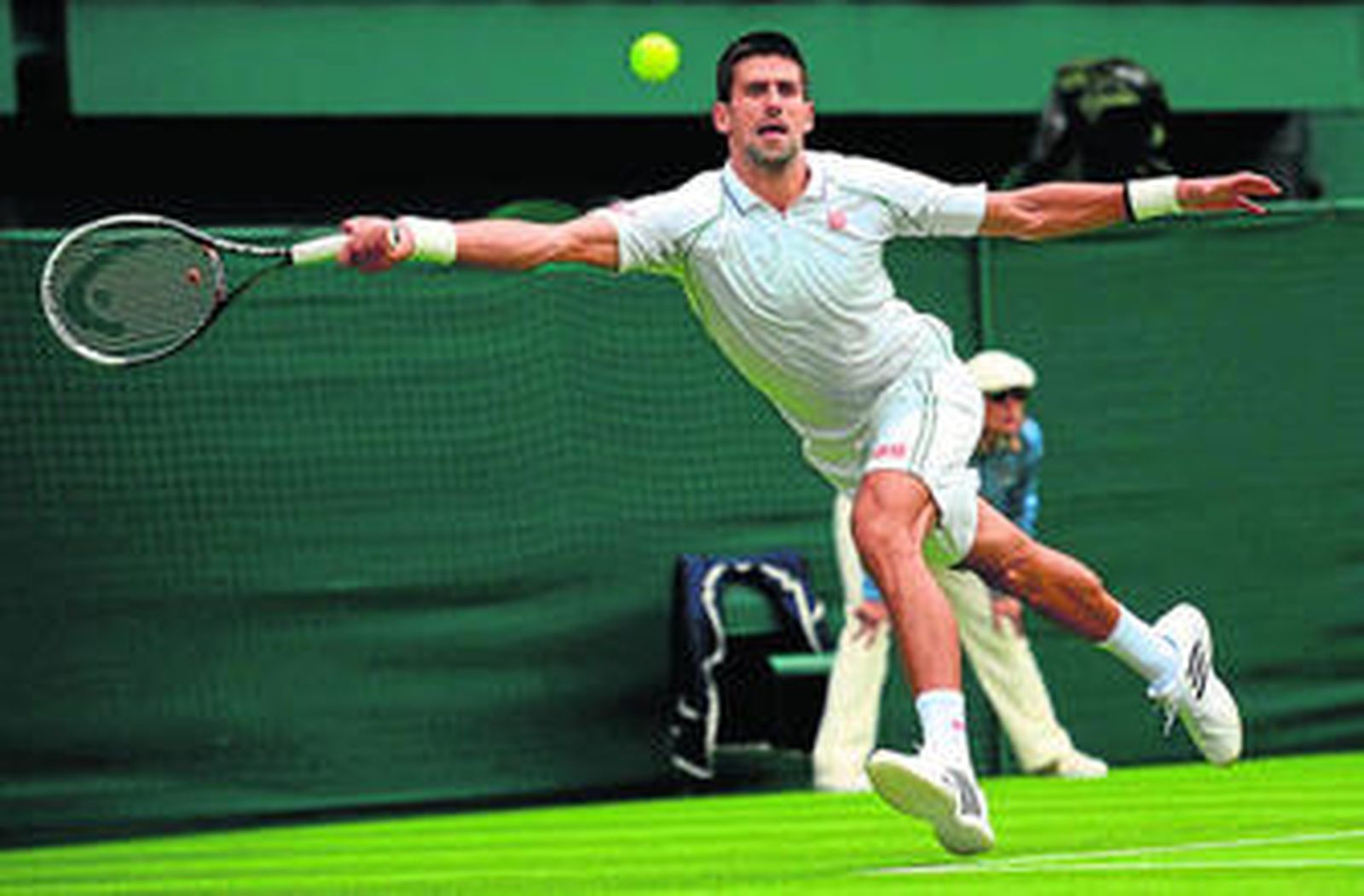 Novak Djokovic llega forzado para devolver la bola con su golpe de derecha a Juan Carlos Ferrero.