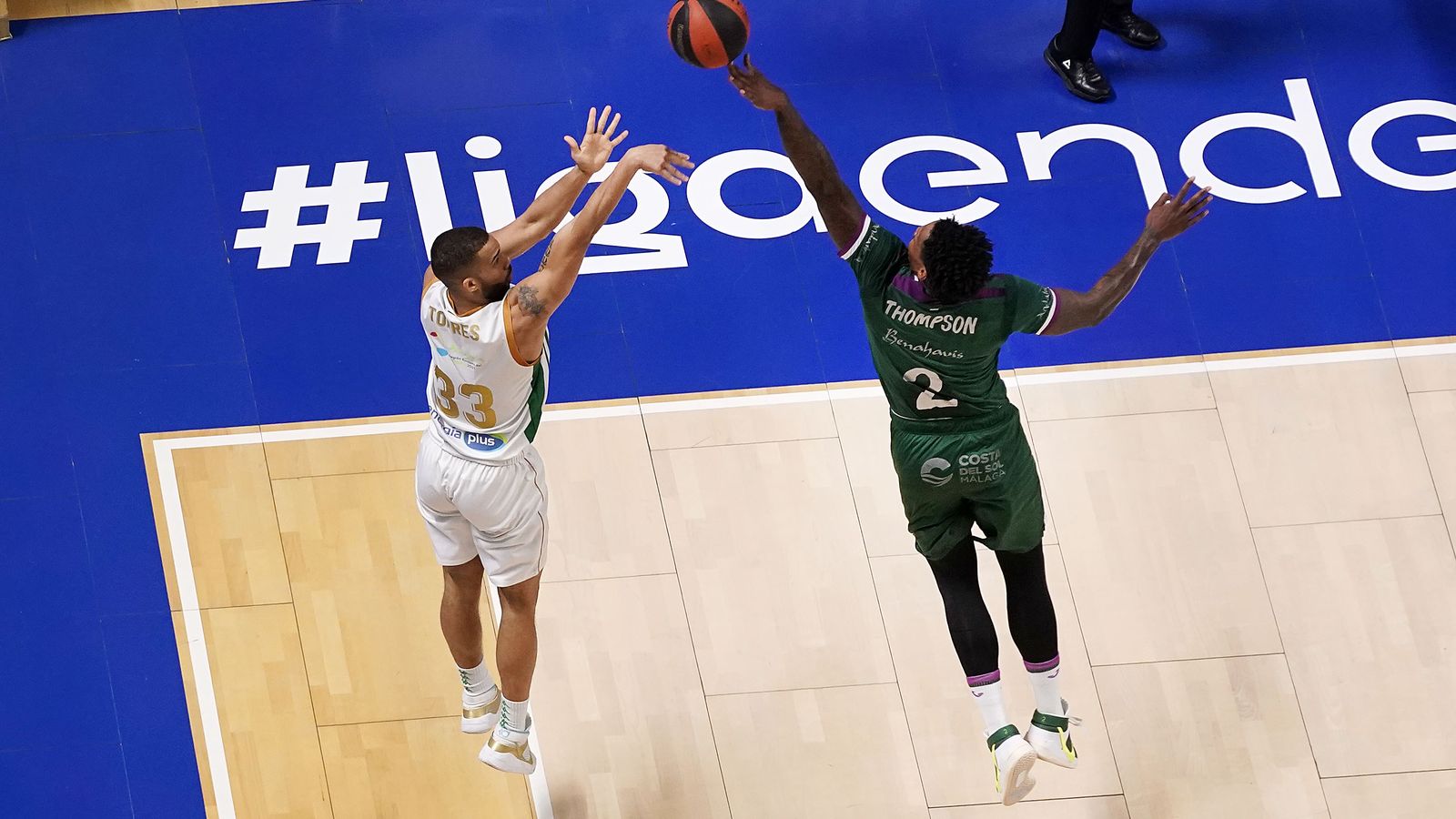 Mike Torres lanza un triple desde la esquina ante la oposición de Deon Thompson en el duelo ante el Unicaja.