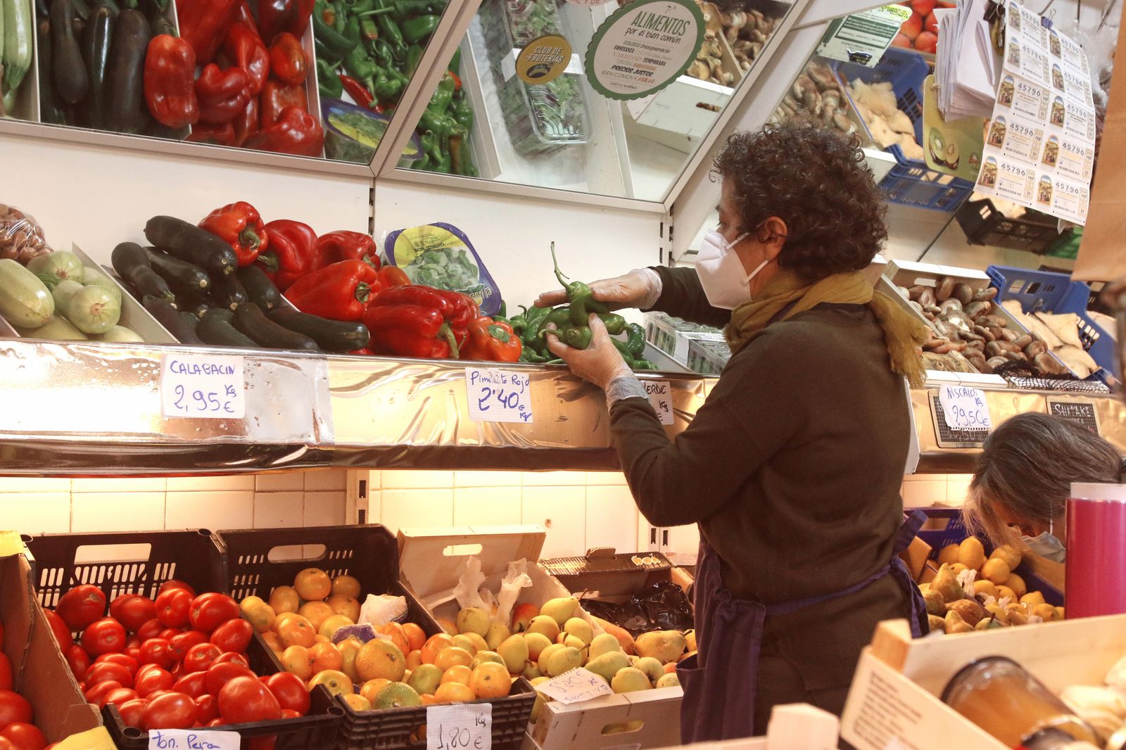 Una mujer trabaja en una frutería en un mercado de Córdoba.
