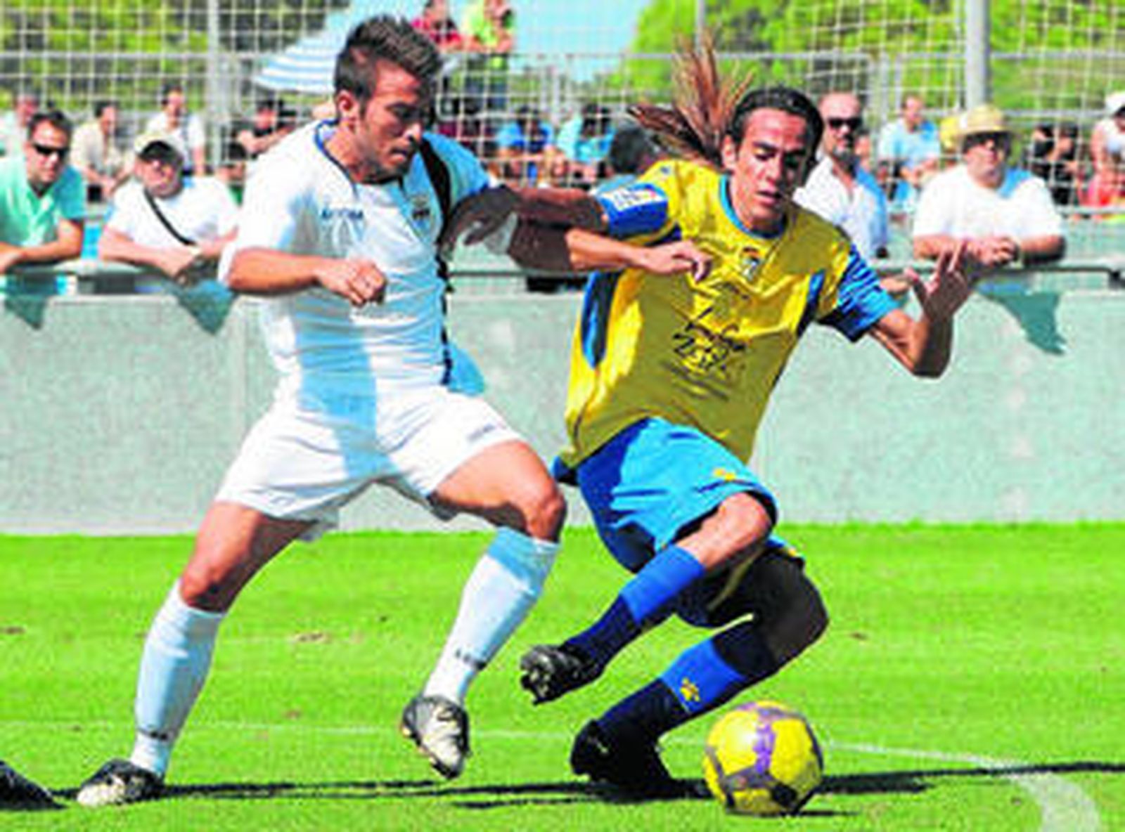 El balonista Raúl Lora (d) pelea por el control del esférico con Fran Mejías, centrocampista del Arcos.
