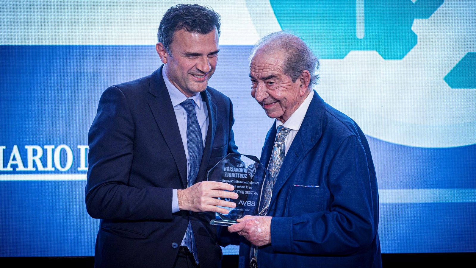 Antonio Mota (i.) sonríe con el premio Innovación Sostenible que le entrega Bruno García.