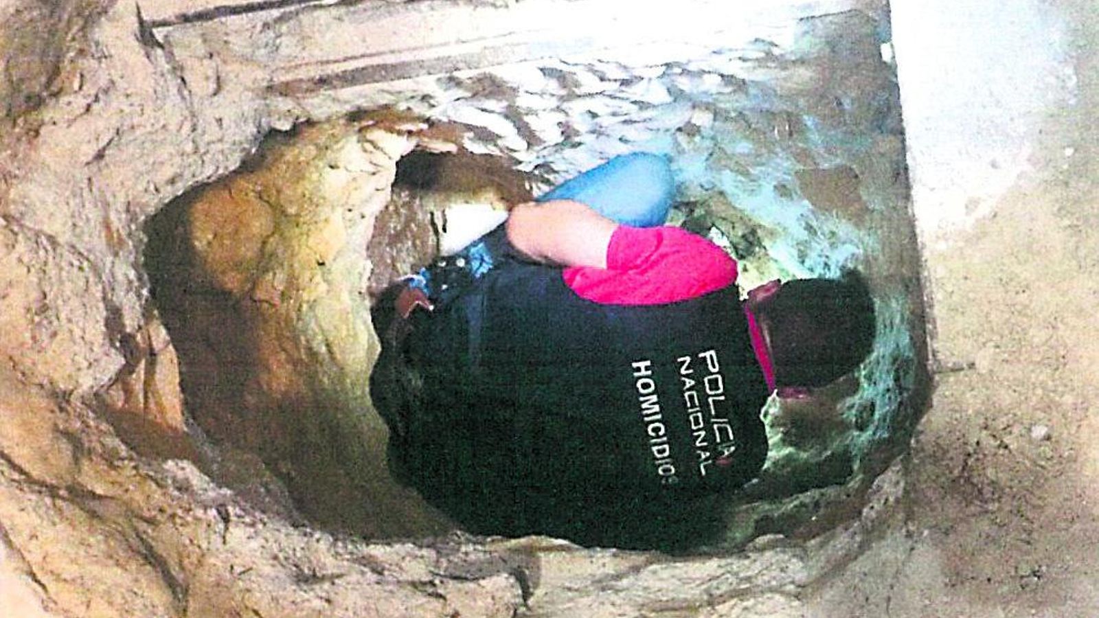 Una captura del atestado policial en la que se ve a un agente introducido en el zulo donde se ocultaron los cadáveres