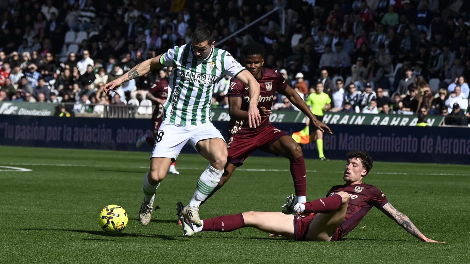 Adri Fuentes controla el balón en presencia de Lalo y Marvel.