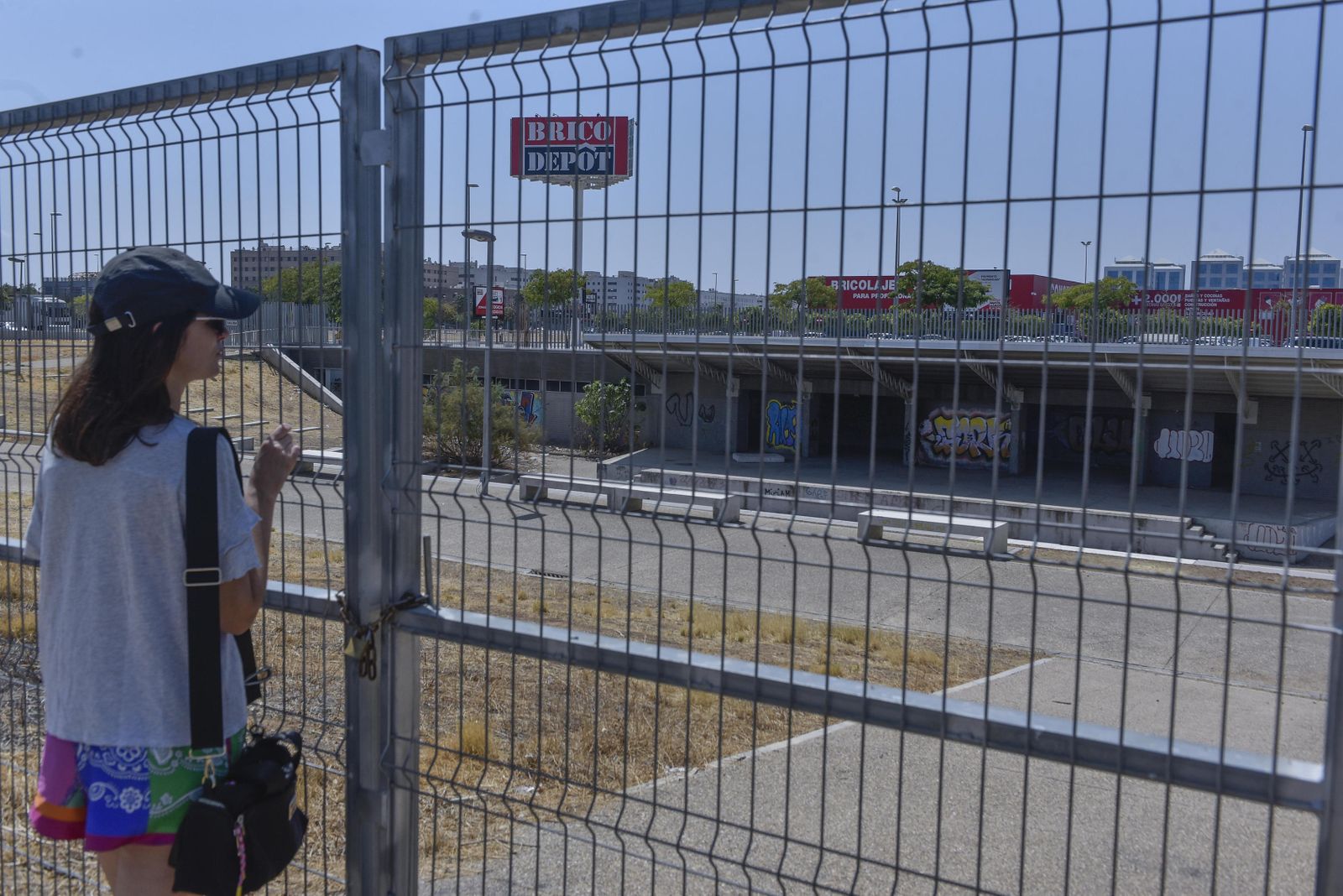 Una joven mira a través de la reja el Auditorio del Higuerón.