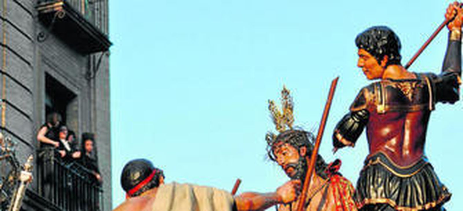 Mujeres de mantilla observan la salida por Laraña del paso del misterio del Cristo de la Coronación de Espinas.