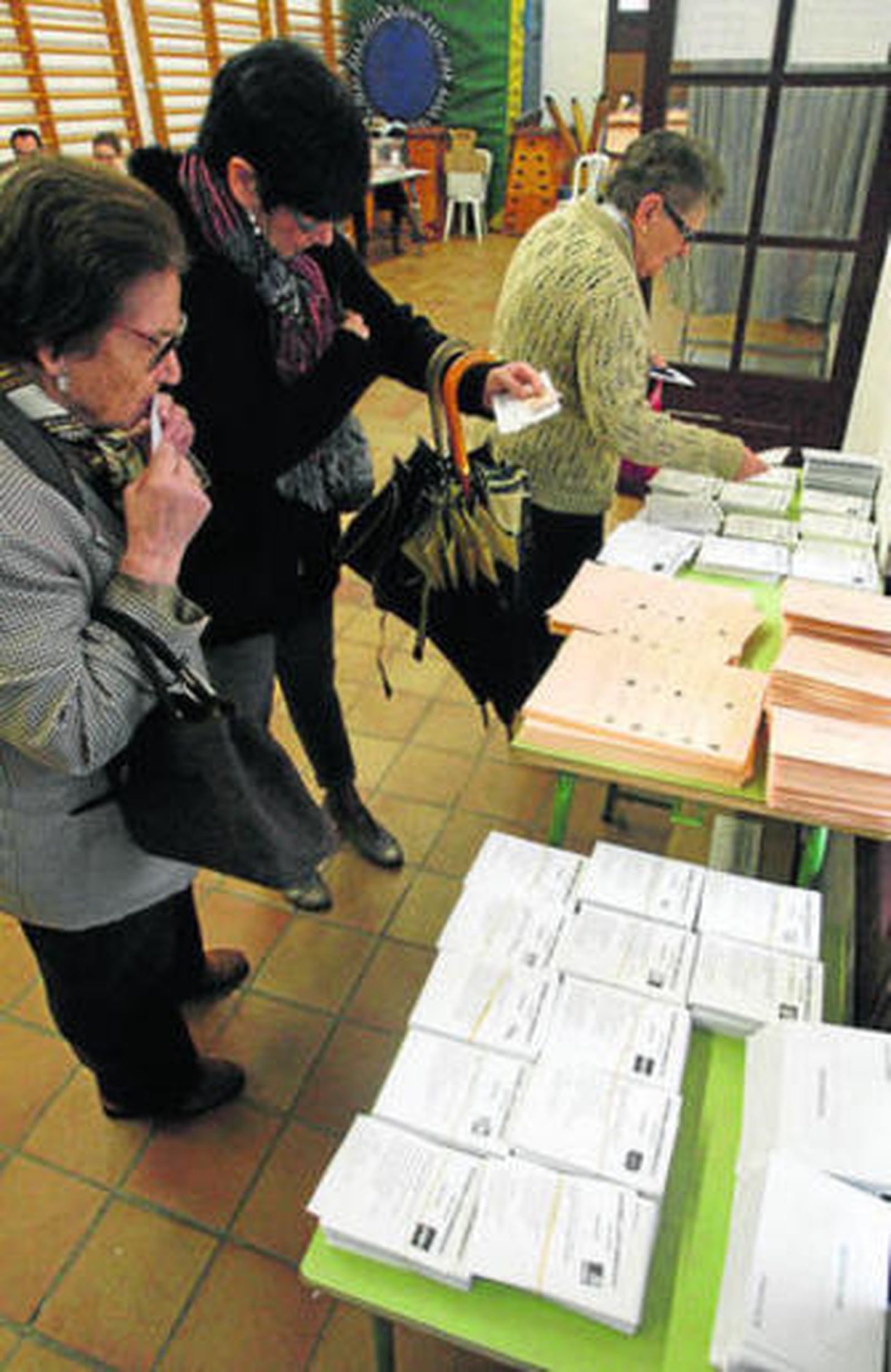 Varios ciudadanos eligen sus papeletas en las últimas generales.