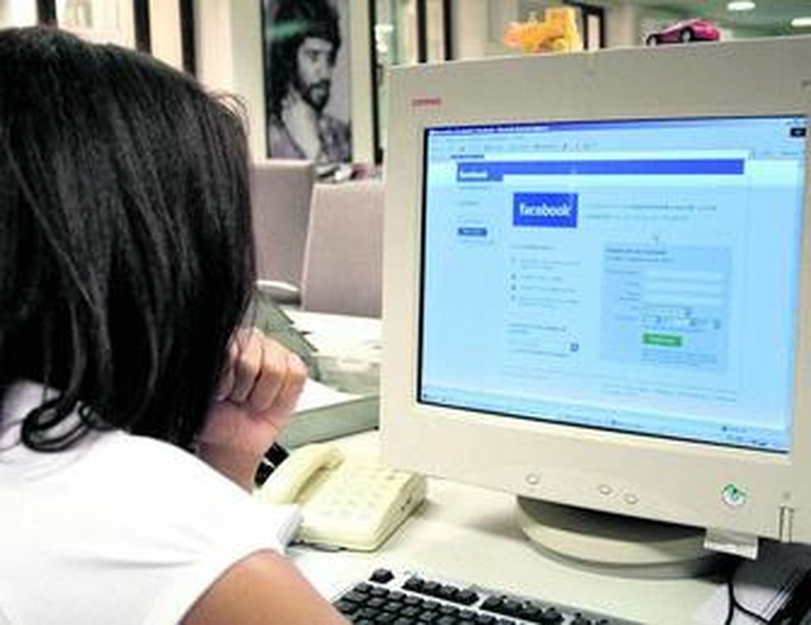 Una chica actualiza su perfil en el portal de Facebook.