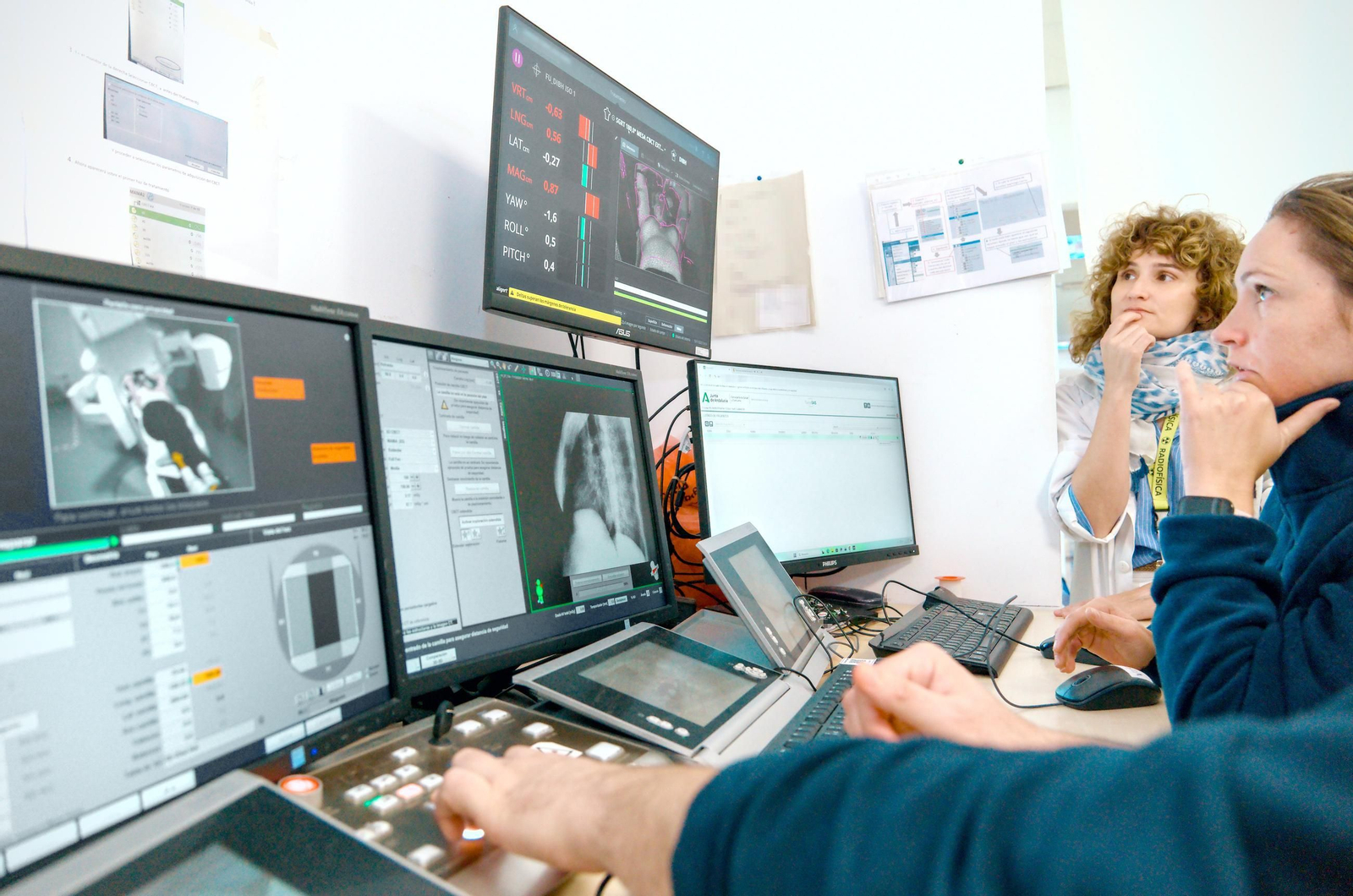 La técnicos vigilan a un paciente mientras recibe la radioterapia.