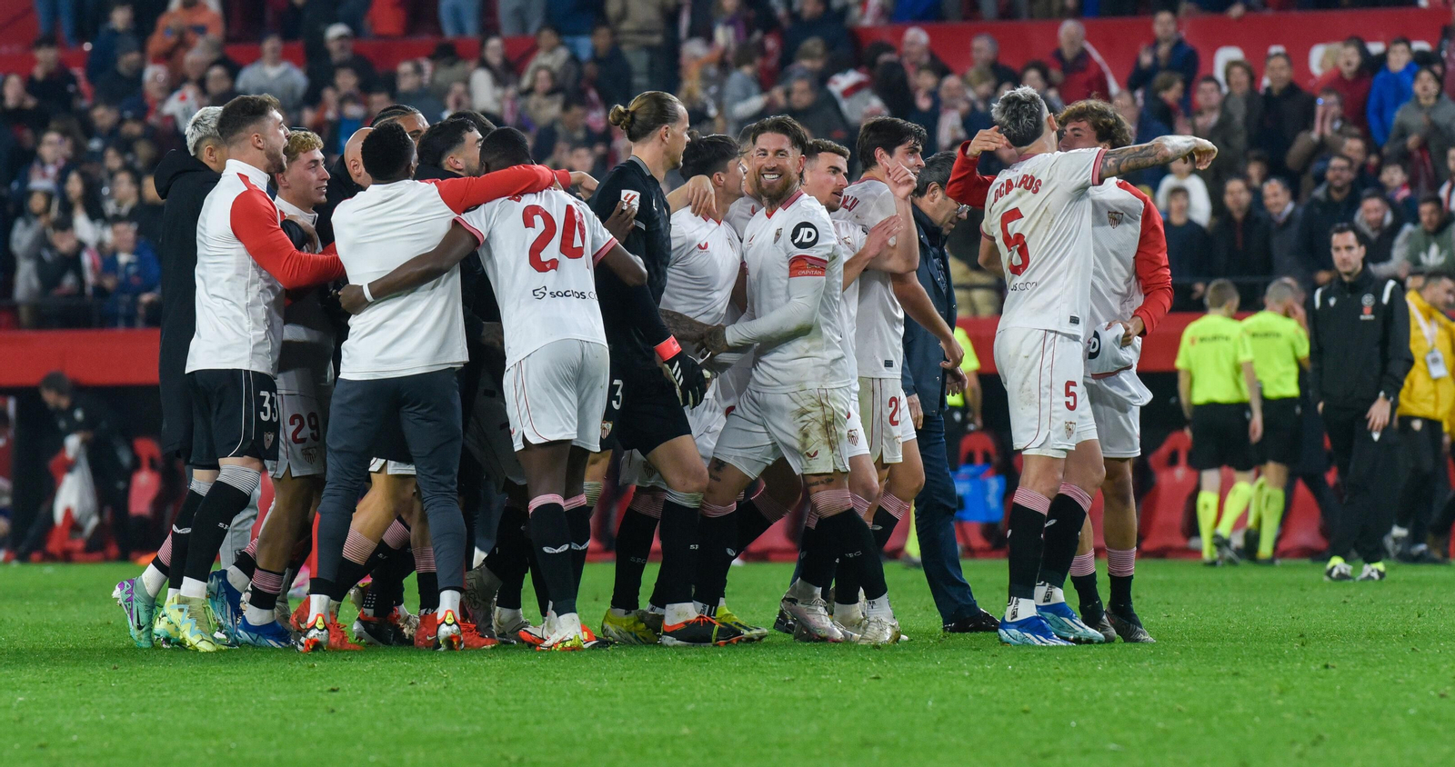 El grupo de profesionales sevillistas celebra eufórico el triunfo en el césped.