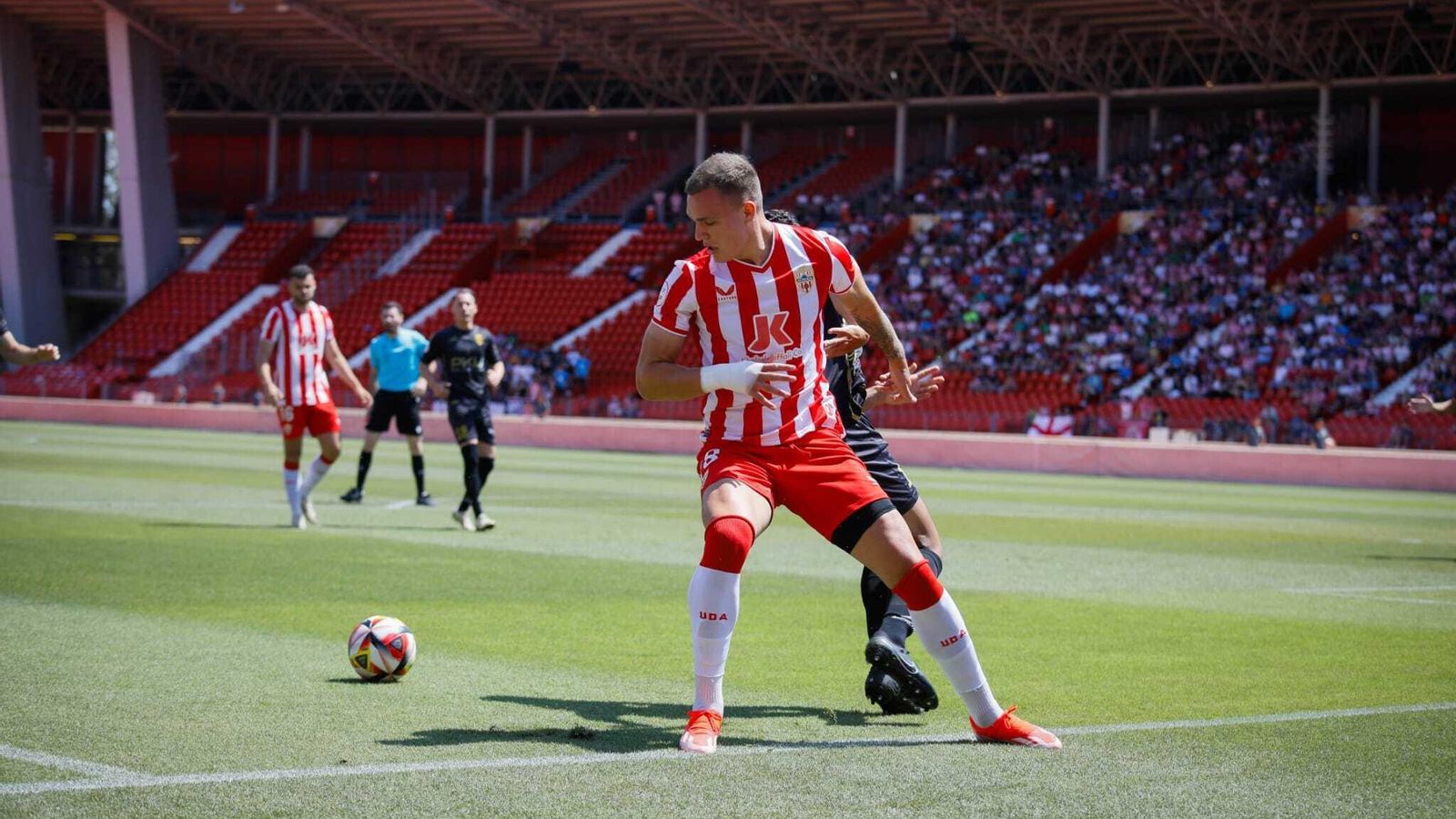 Marezi trata de irse con el balón ante la presión de espaldas de un futbolista jienense.