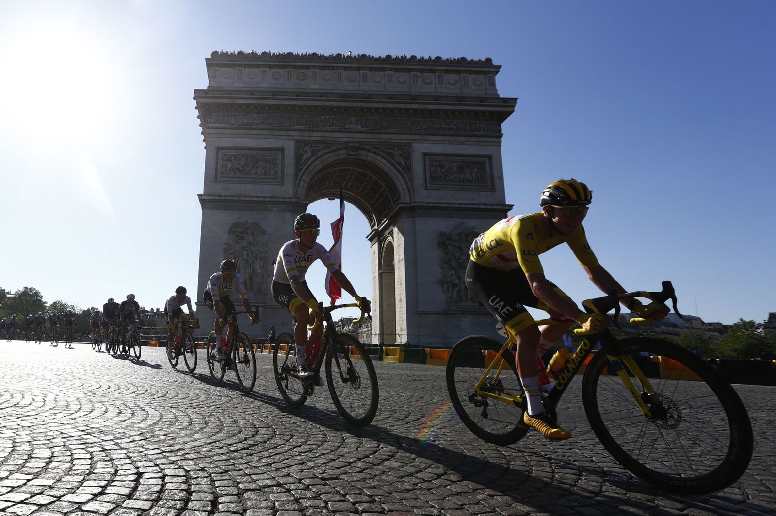 Pogacar (d) ante el Arco del Triunfo de París.